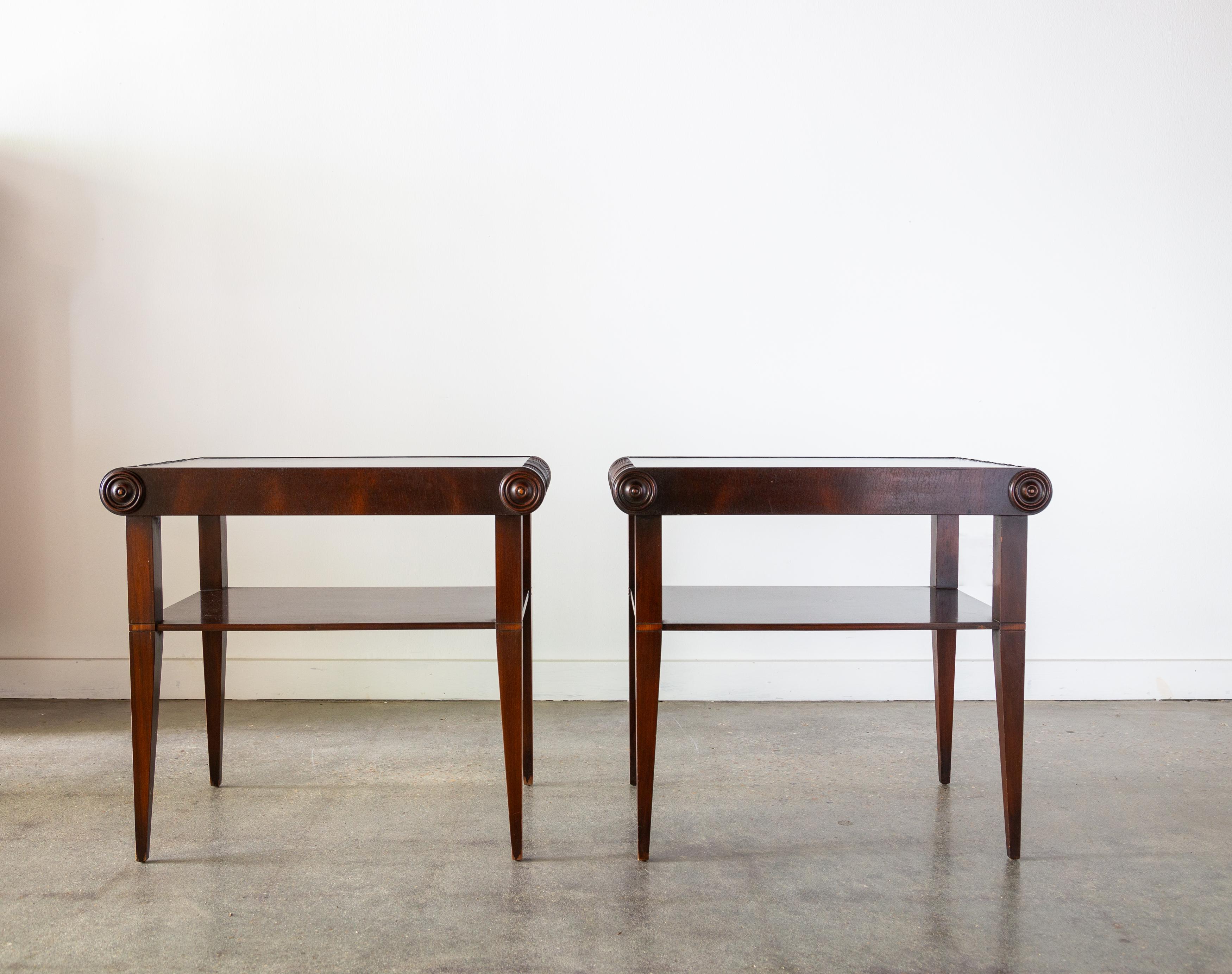 A pair of 1920s Art Deco Swedish end tables/nightstands with a lower shelf.  Mahogany frames with black leather tops. Intricate scrolled sides with tapered legs. 

Dimensions: 25.5”W x 16.5”D x 23.25”H

Condition: Good vintage condition. Shows a