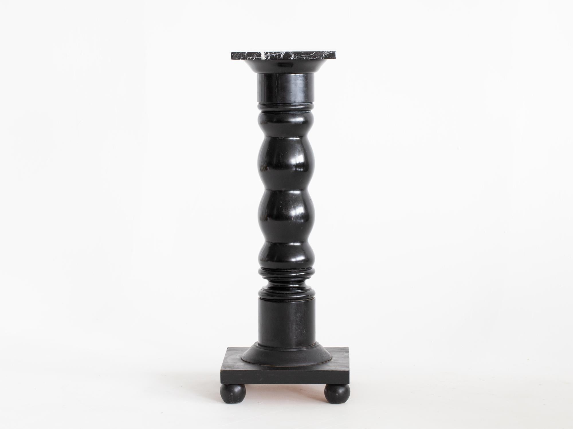 A bobbin-turned ebonised column or pedestal with black veined marble top, raised on bun feet. Swedish, c. 1920s.

In good sturdy order with light cosmetic wear.

91 x 34 x 34 cm (35.8 x 13.4 x 13.4 