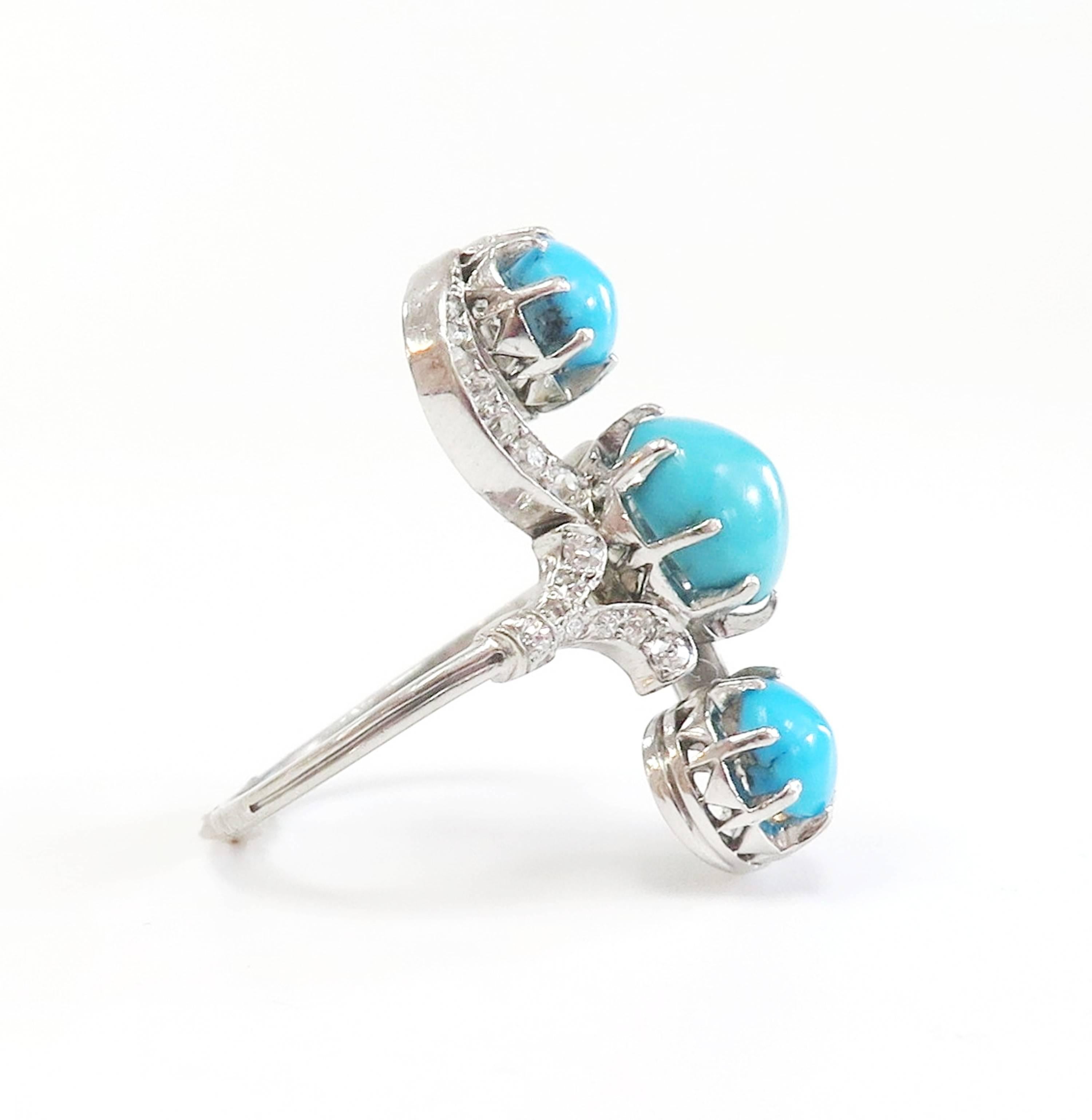 A stunning Early Twentieth Century elongated ring, encrusted with sparkling white old European and Rose cut diamonds and featuring 3 beautiful robins egg color turquoise. The ring is constructed in Platinum, the 3 Turquoise Cabochon stones within 2