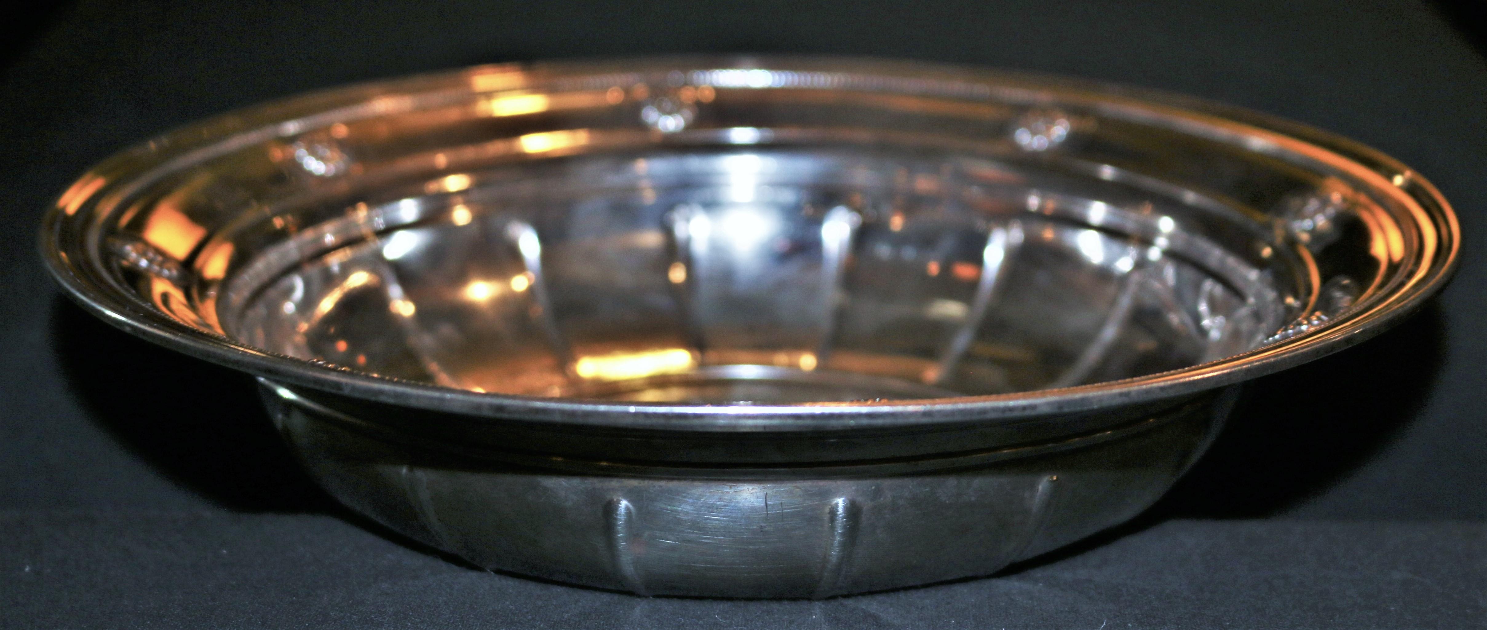 A 1920s Tiffany & Co. sterling silver scalloped low bowl or dish. Marked Tiffany & Co. makers Sterling Silver 925-10000.
A floral design with 8 flowers around the inner rim of the bowl.
The bottom of the bowl has ridges adding aesthetic value to