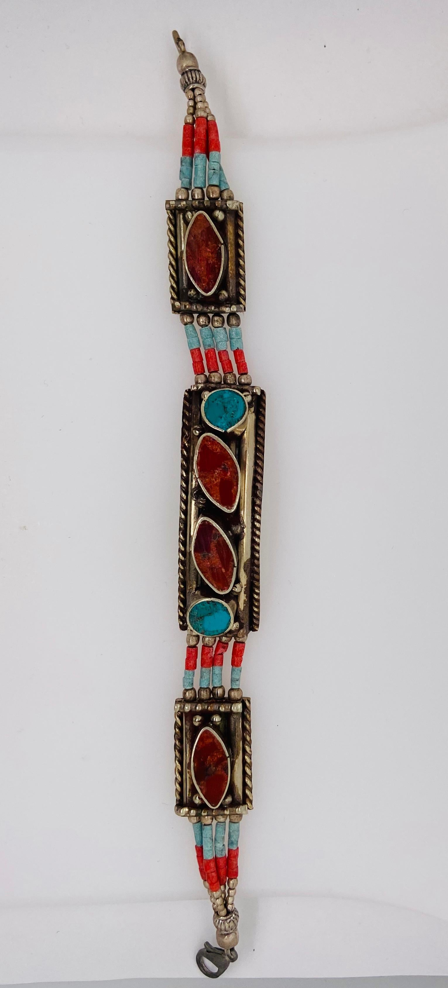 A lovely handmade Moroccan Berber tribal pure silver bracelet. This beautiful and one of a kind piece of jewelry made around 1920's in the Atlas Mountains in Morocco features genuine turquoise and red stones finely tear-shaped The impressive