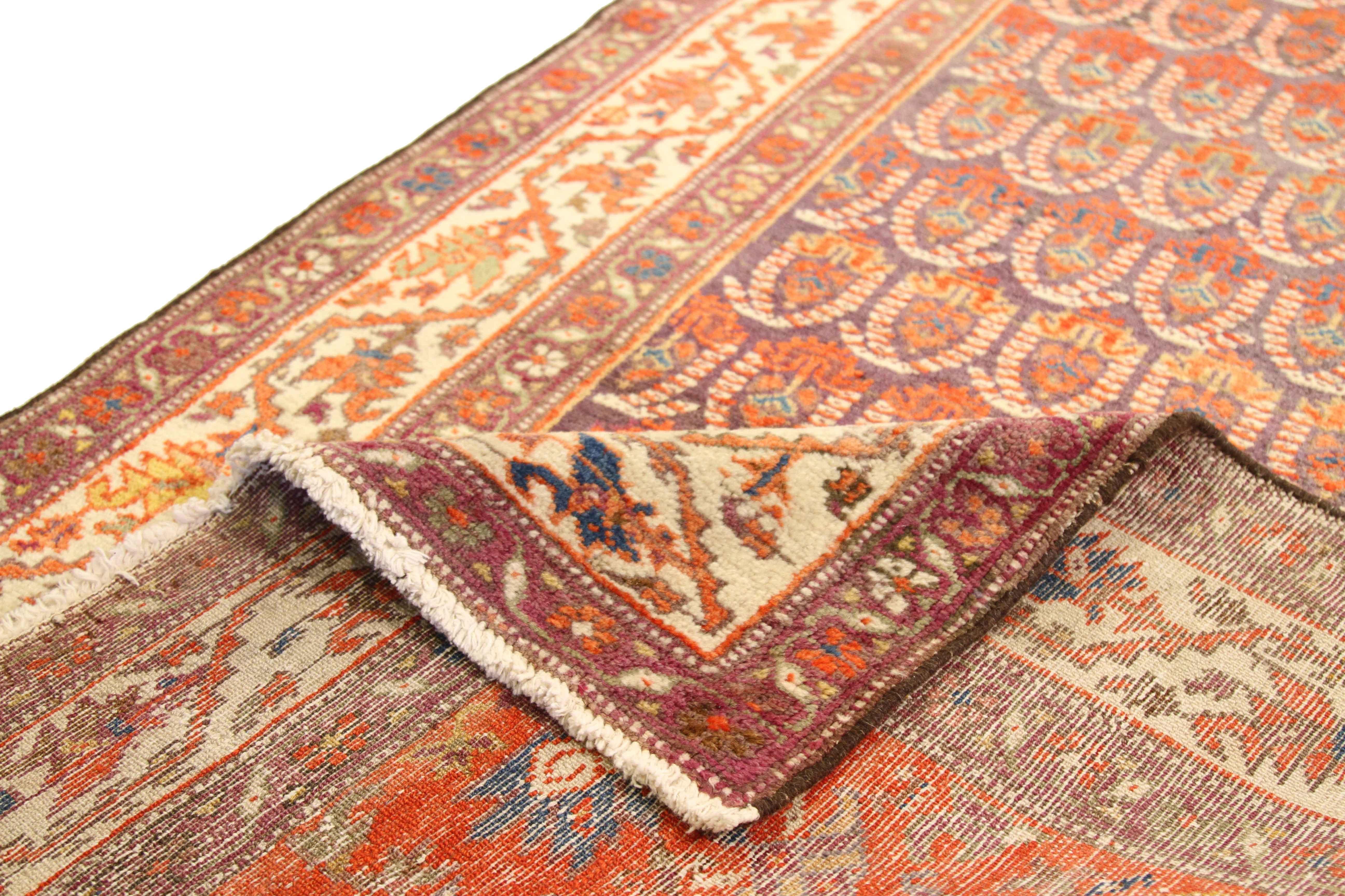 Made from the finest wool and natural vegetable dyes, this antique Persian rug features repeating patterns of traditional emblems reminiscent of ancient Persian royalty. The blend of majestic hues like purple, ivory, and red make it an ideal piece