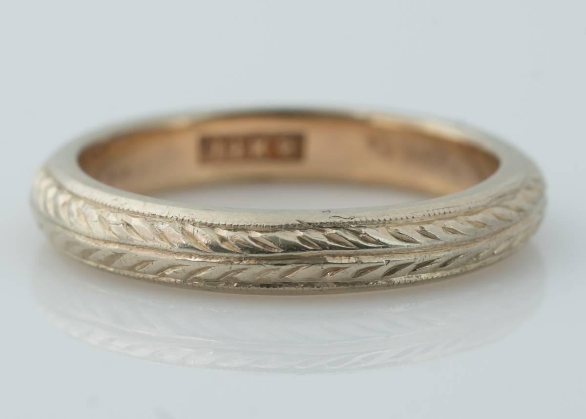 1920s Art Deco Two Tone 14 Karat Gold Wedding Band Ring

This classic ring features a Wheat Pattern with very fine milgrain borders all the way around. The outer face of the ring is 14 Karat White Gold. The inner band is crafted from 14 Karat Yellow