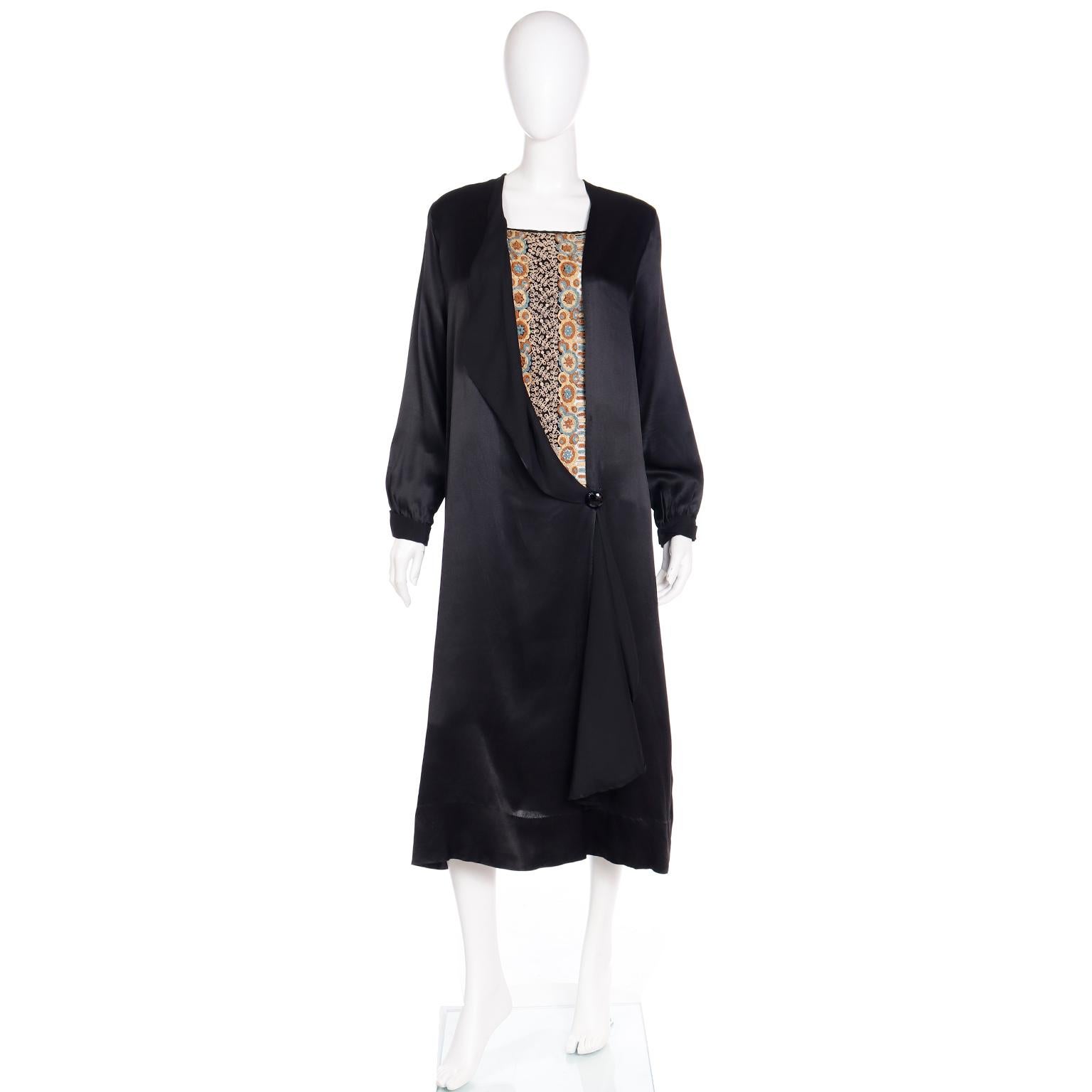 This true vintage 1920's black silk dress is accented with intricate fine hand embroidery including beautiful couching. This beautiful detail makes this dress so special. The embroidery creates a lovely floral pattern in a variety of hues including