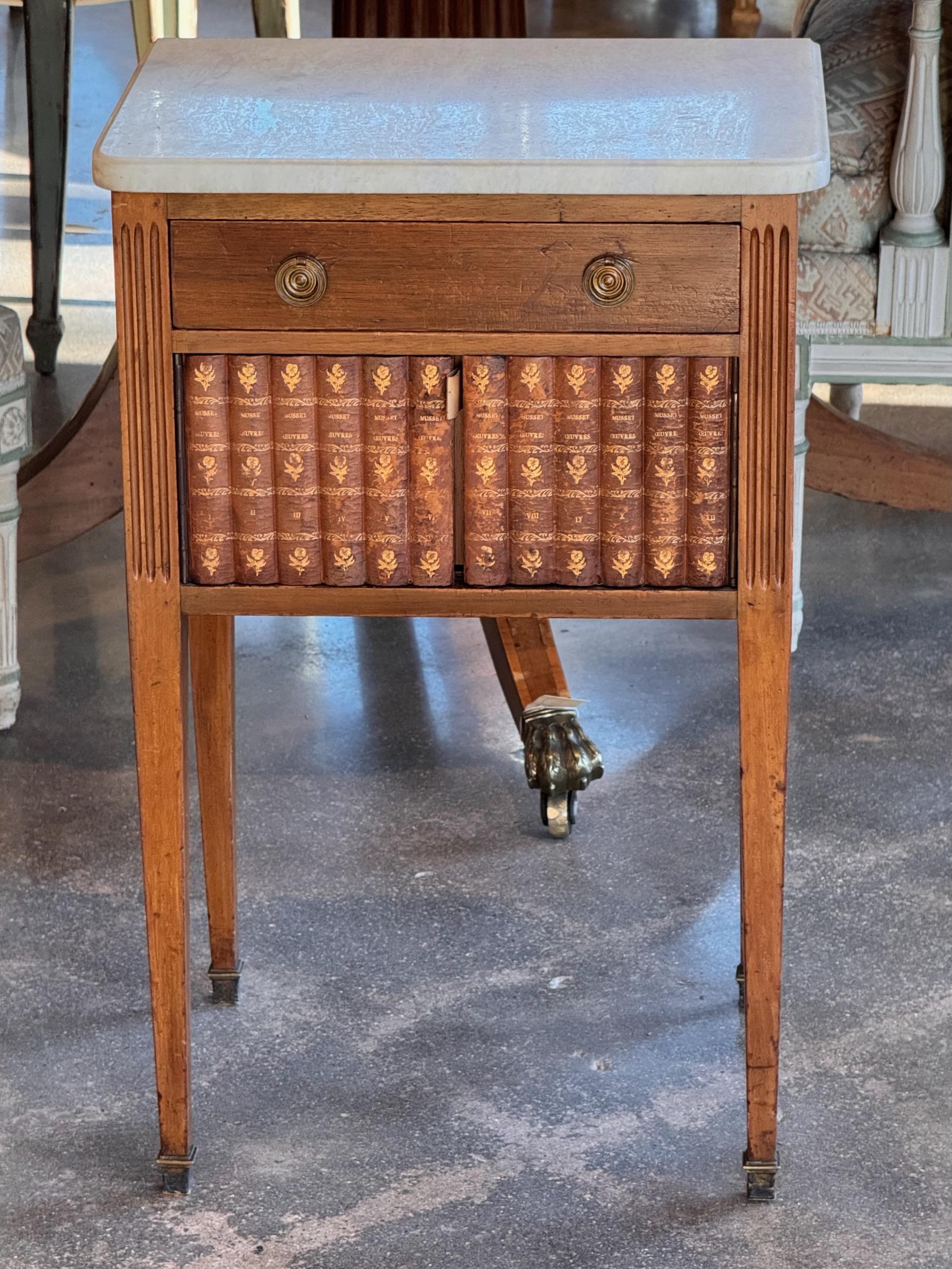 Un joli meuble d'appoint français, avec une porte en forme de livre.