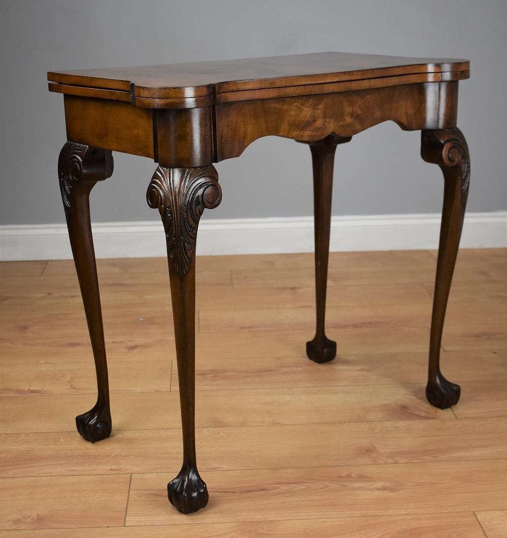 1920s walnut serpentine card table with green baise and supported by carved cabriol legs with claw and ball feet in good condition.