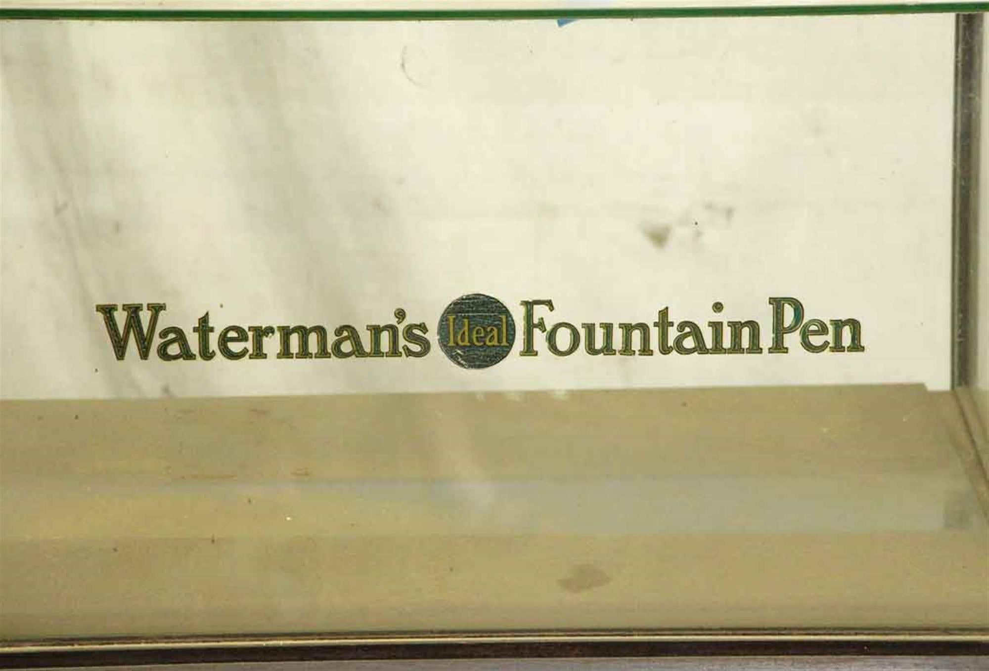 1920s original Waterman's ideal fountain pen wood and glass showcase with original lettering on both the glass and the wood. This needs cleaning up, but is in overall good condition. This can be seen at our 400 Gilligan St location in Scranton, PA.