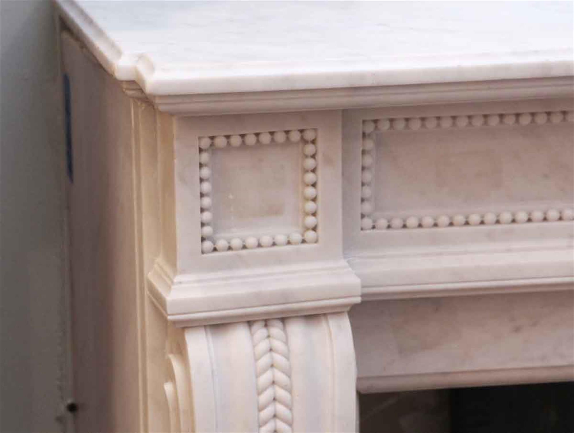 1920s carved white beaded marble mantel with fine details. This can be seen at our 5 East 16th St location on Union Square in Manhattan.