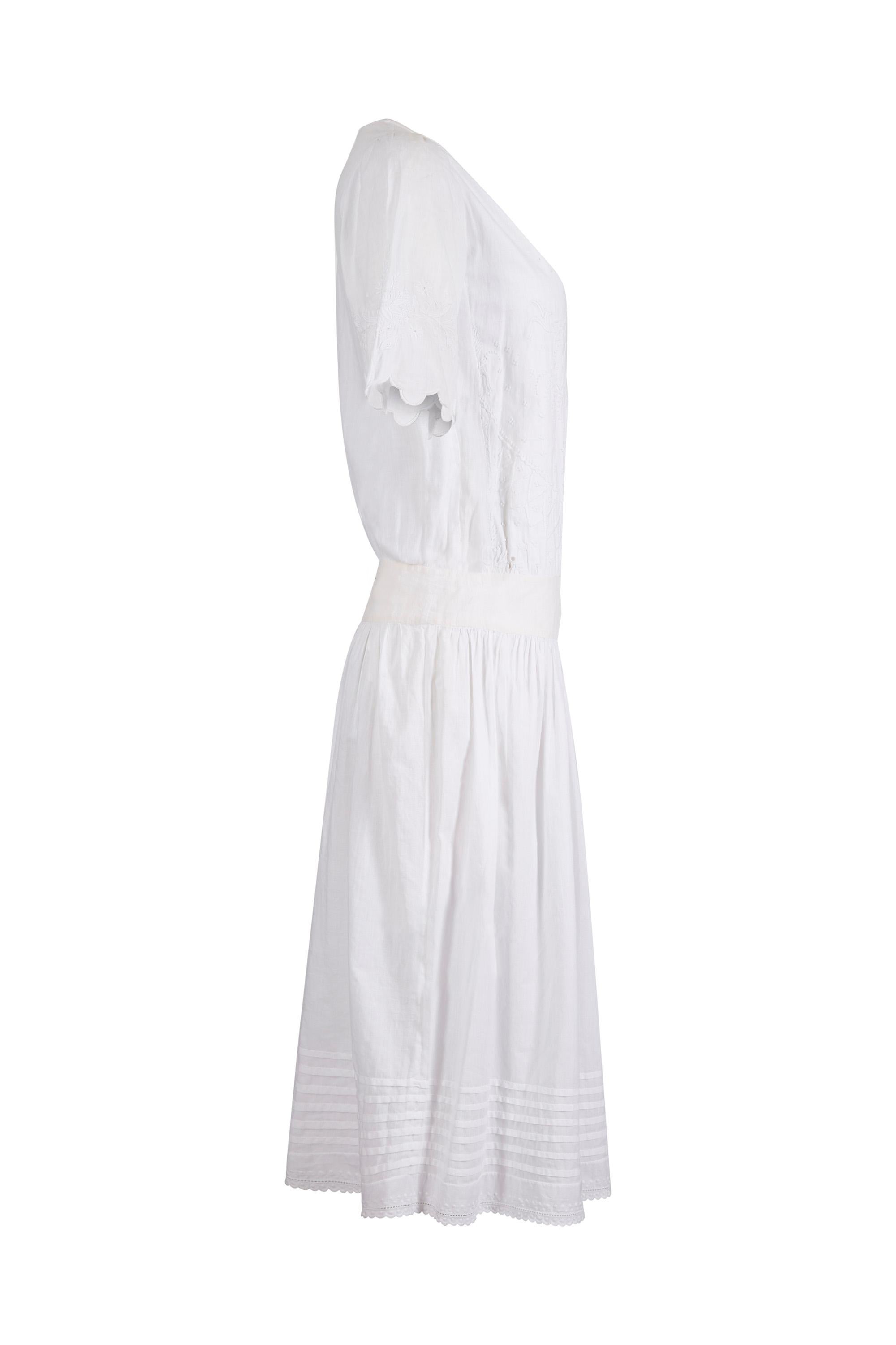 Cette exquise robe de thé antique des années 1920 en coton brodé à la main est dans un état vintage absolument étonnant pour une pièce de cette époque, sans aucun défaut à mentionner et ferait un choix enchanteur de vêtements de mariée alternatifs.
