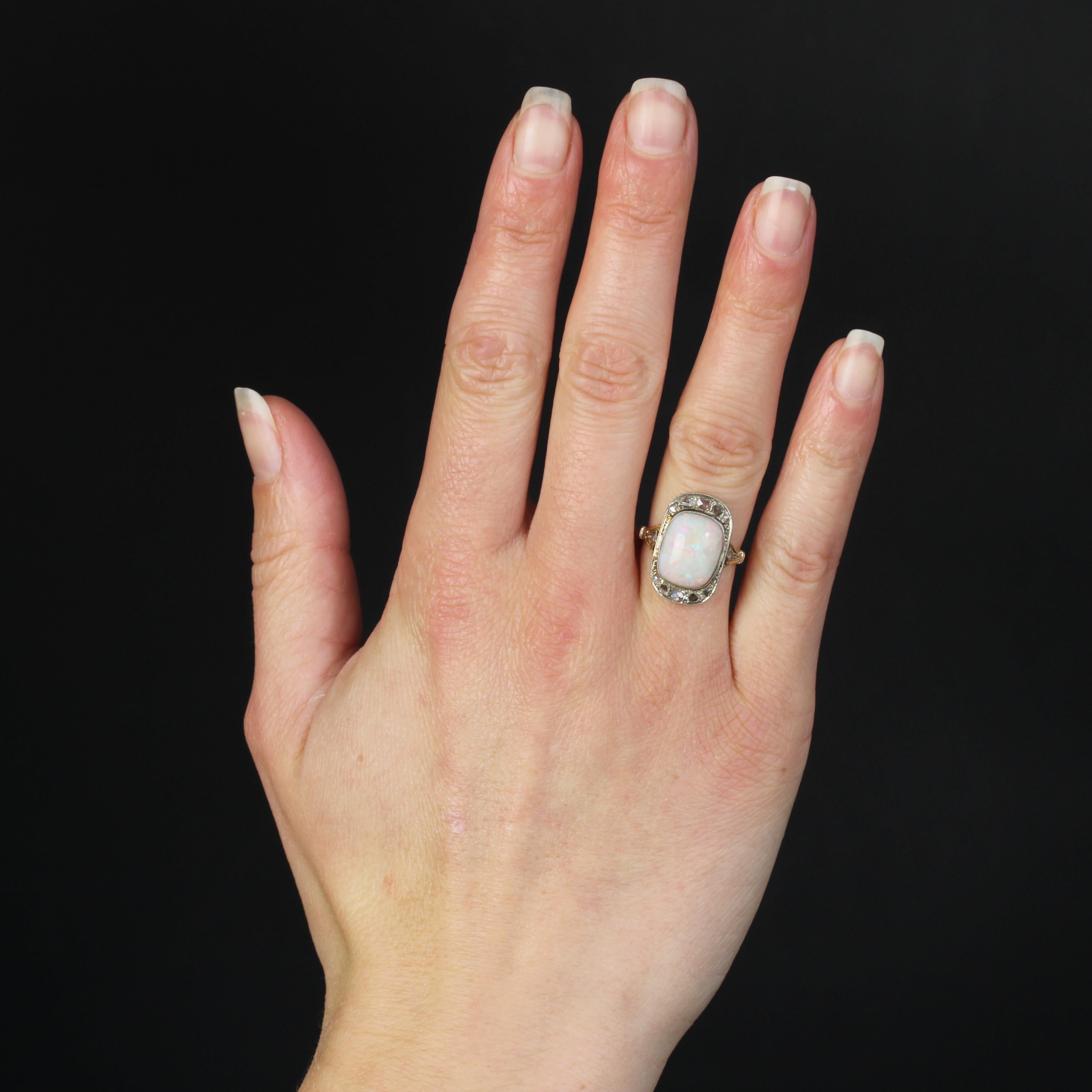 Ring aus 18 Karat Gelbgold und Platin.
Dieser elegante Opalring im Art-Déco-Stil ist mit Diamanten im Rosenschliff besetzt und hat eine rechteckige Form mit abgerundeten Ecken. In der Mitte ist ein australischer Cabochon-Opal gefasst. Auf beiden