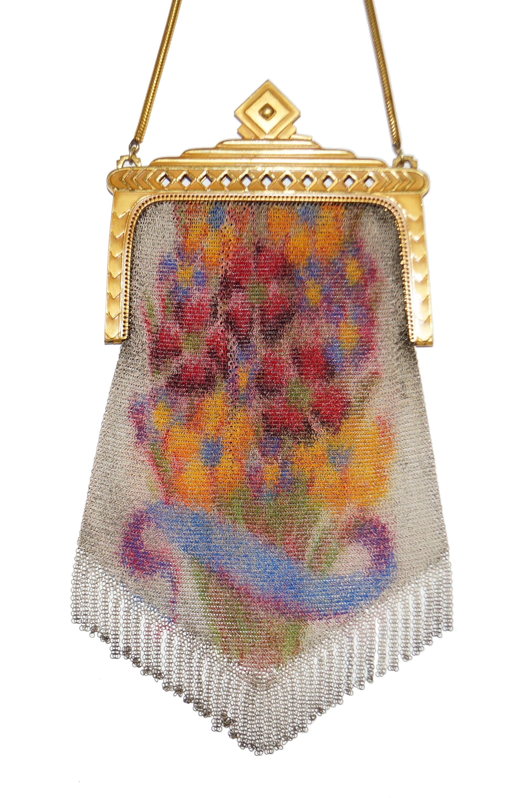 Stunning floral thin Dresden mesh evening bag by Whiting & Davis. This elegant and elaborate 1920s evening purse has a diamond art deco clasp with pressed out details. The mesh body of the purse features a floral bouquet design with orange tipped
