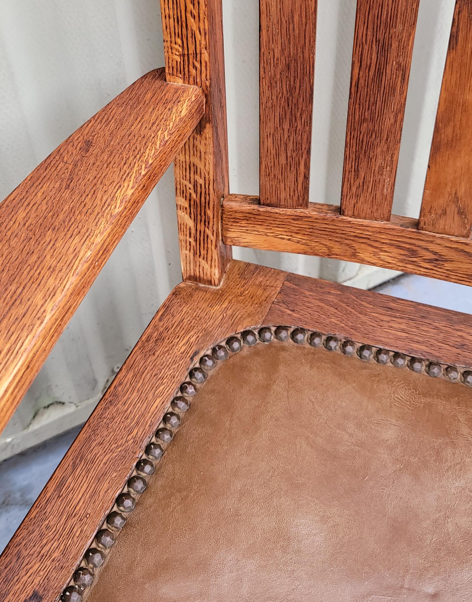 1920s arts and crafts wooden child's chair with original leather seat and brass tacks around the seat. 