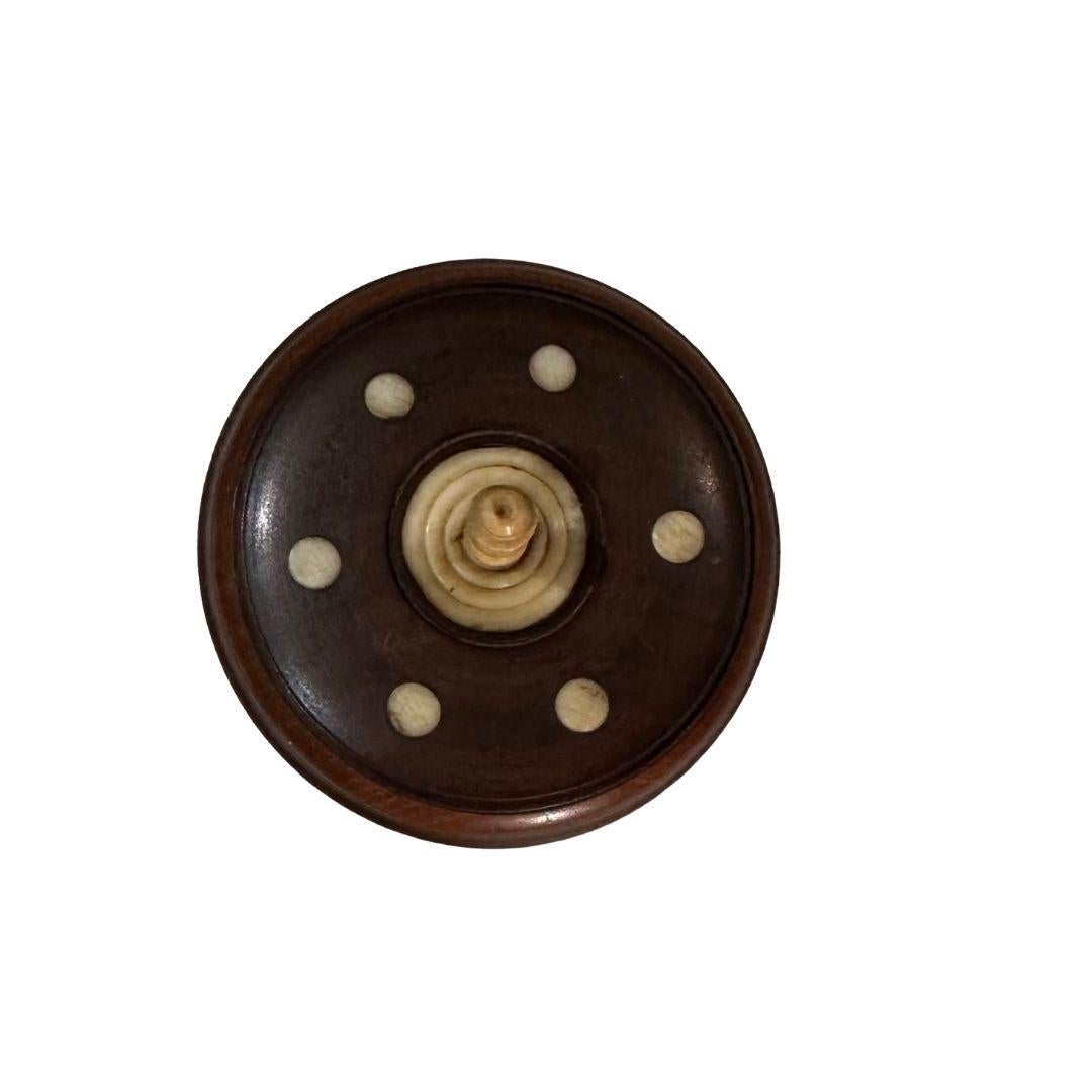 A round wooden box from India. Might be some type of exotic rosewood. Circa 1920s, maybe a little earlier. Box with six ivory dots on lid, ivory feet and finial.