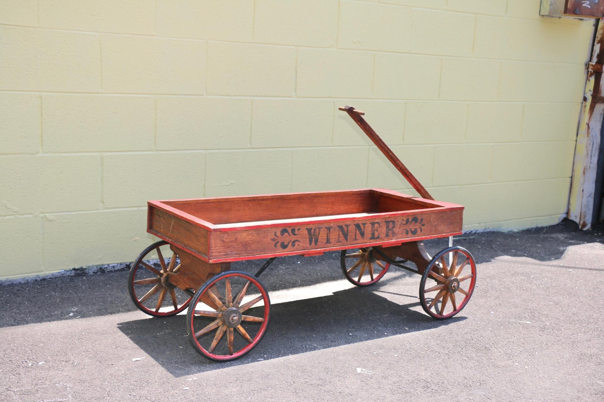 Rustic antique wood wagon from the early 1900’s. Great used condition. Hand painted has nice res accent color. Works well. Can be used for decor.
