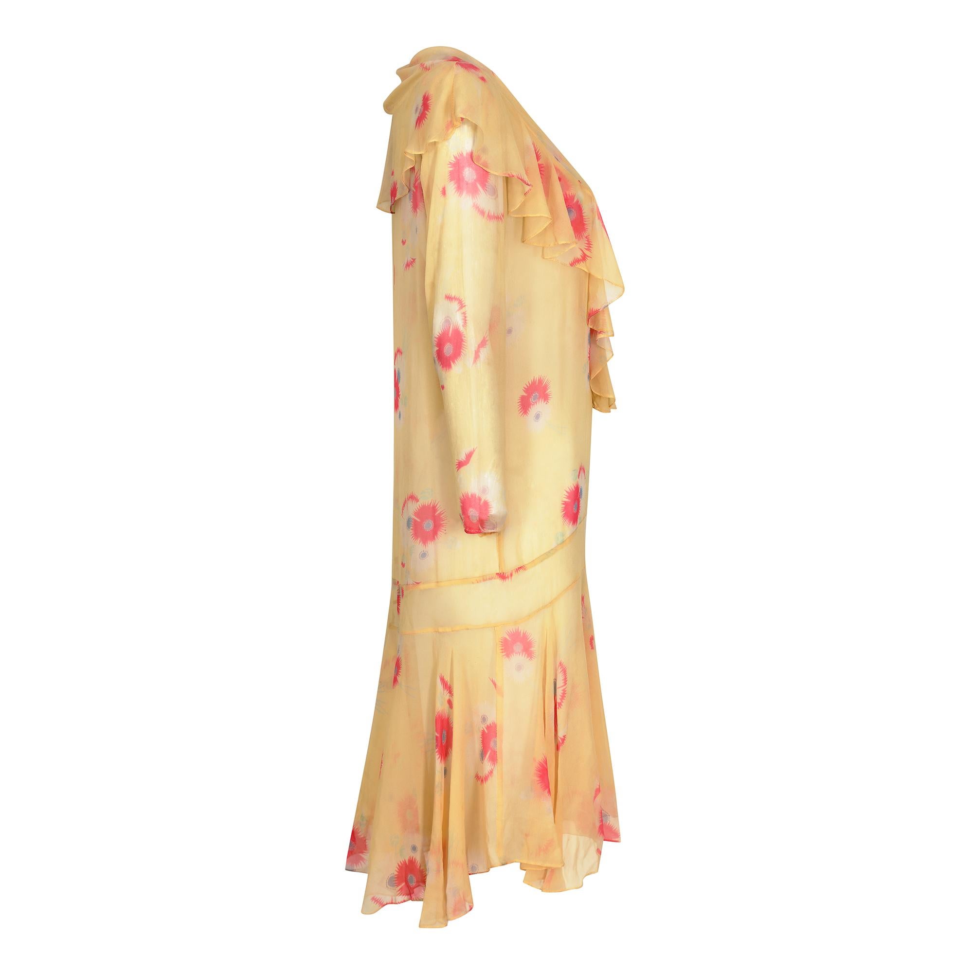 This charming original 1920s silk chiffon floral print dress is delicate, feminine and in excellent antique condition. The pale yellow chiffon hosts a subtle abstract floral design in deep rose pink and lilac blues and has an air of understated