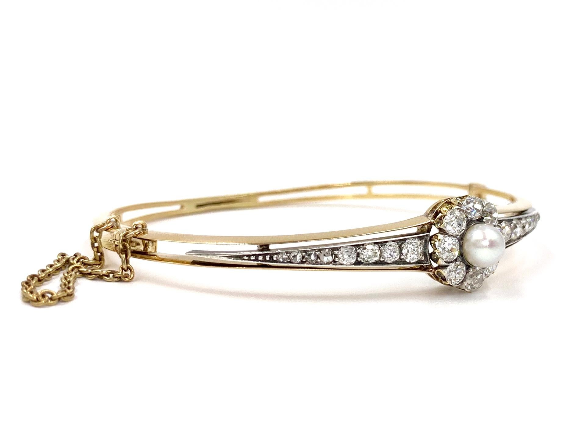 Circa 1920's this beautiful and elegant 14 karat two tone bracelet features approximately 3.50 carats of old European cut diamonds and one 5.5mm lustrous cultured pearl. Diamonds are approximately G color, SI1 clarity. Flower shaped center has a