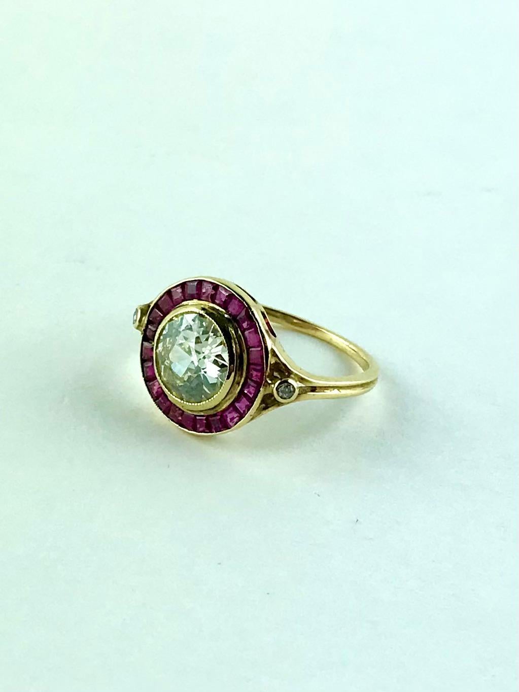 This extremely chic 1920s 18K Yellow Gold  Ring , centers a sparkling old cut Diamond that weighs approx 1.60 cts. Accentuating the center stone are 23 carré and carré calibré cut Rubies to provide the perfect contrast and laterally complemented