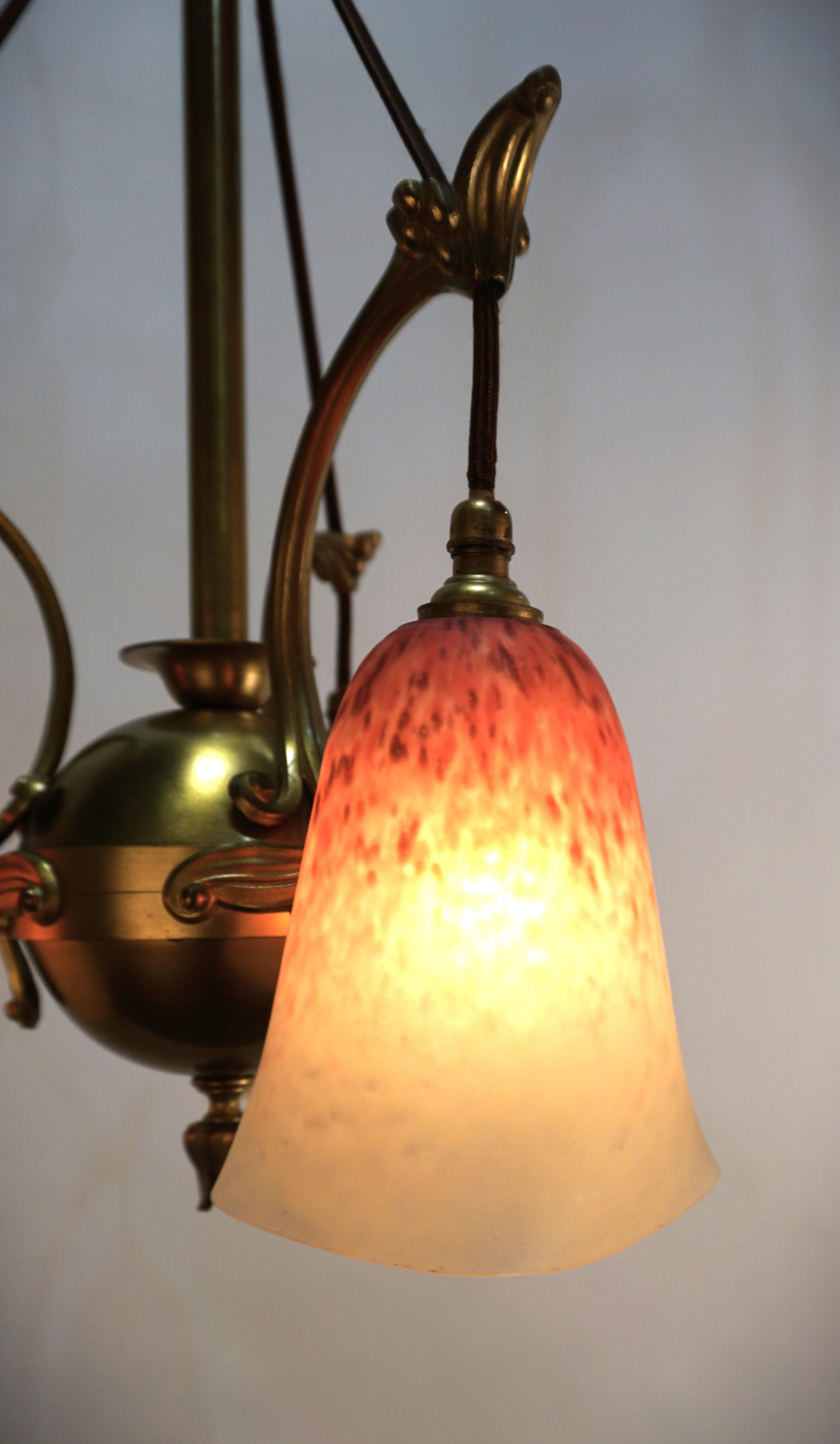 Hand blown art glass shades hanging with fabric cord from bronze frame art nouveau chandelier by Charles Schneider.
Professionally rewired and ready for installation.