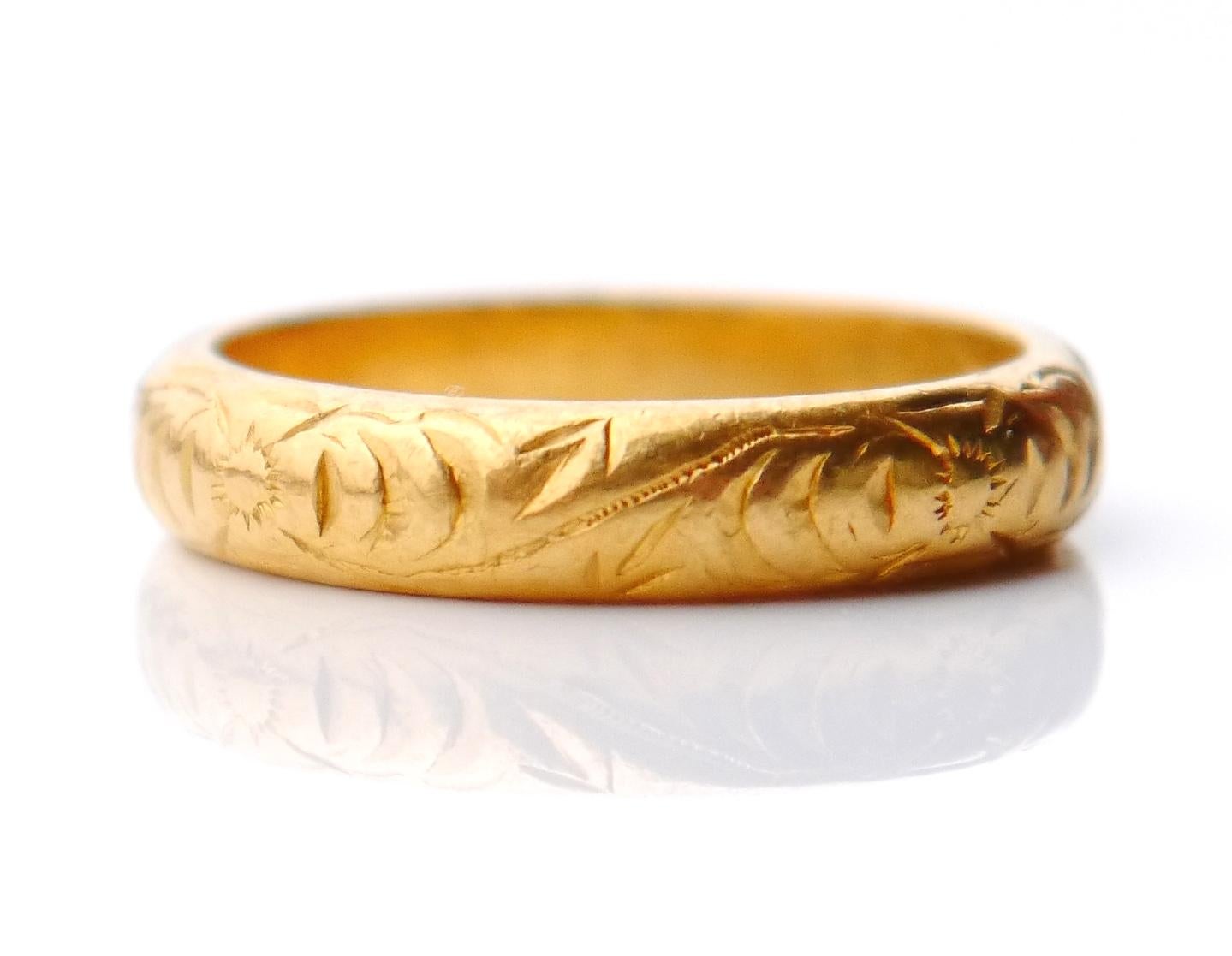 Old Wedding Ring with continuous hand-engraved floral ornament on the band, in solid 23 K Gold.

This ring has Swedish hallmarks, unknown to me maker , 23K , Stockholm. Made in 1921 (year marks T7) .

Size: Ø US 5.5 / 16.10 mm. The band is 4 mm