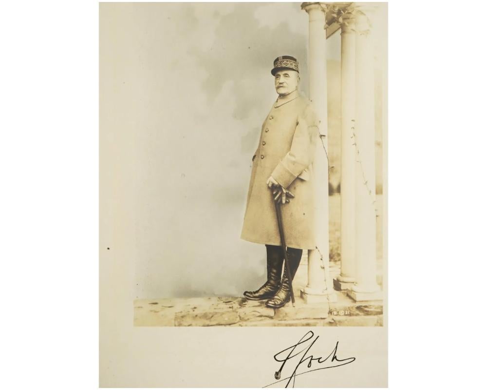Photographie ancienne de Frank Moore, teintée à la main, représentant Ferdinand Foch en manteau, bottes et bonnet d'uniforme portant les bandes caractéristiques de feuilles de chêne. Ferdinand Foch, 1851-1929, est un général français et un