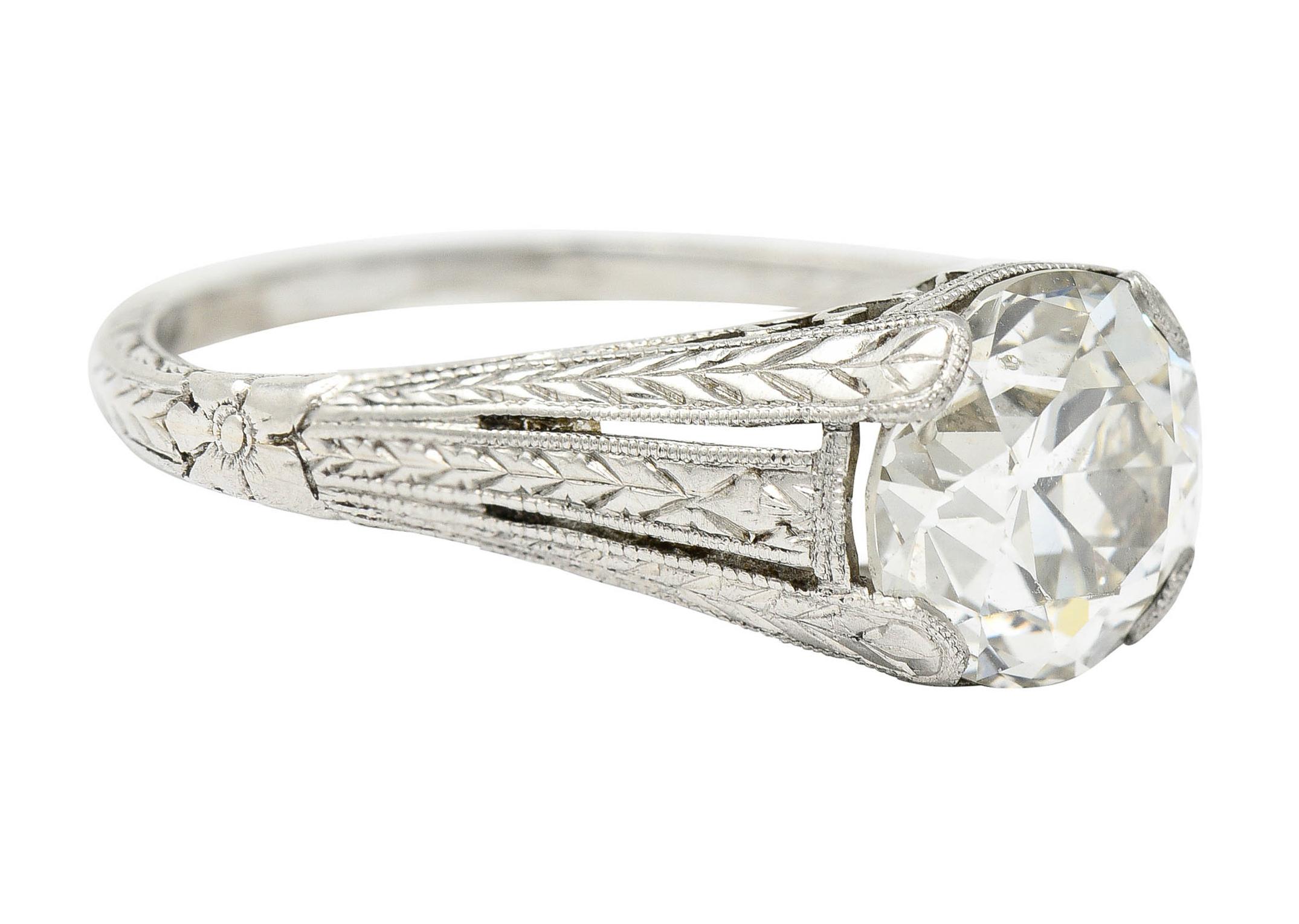 Centering an old European cut diamond weighing 1.79 carats - K color with SI clarity

Set by wide prongs with a pierced gallery depicting a scrolling lotus motif

With deeply engraved tri-split shoulders depicting a wheat motif and orange blossom