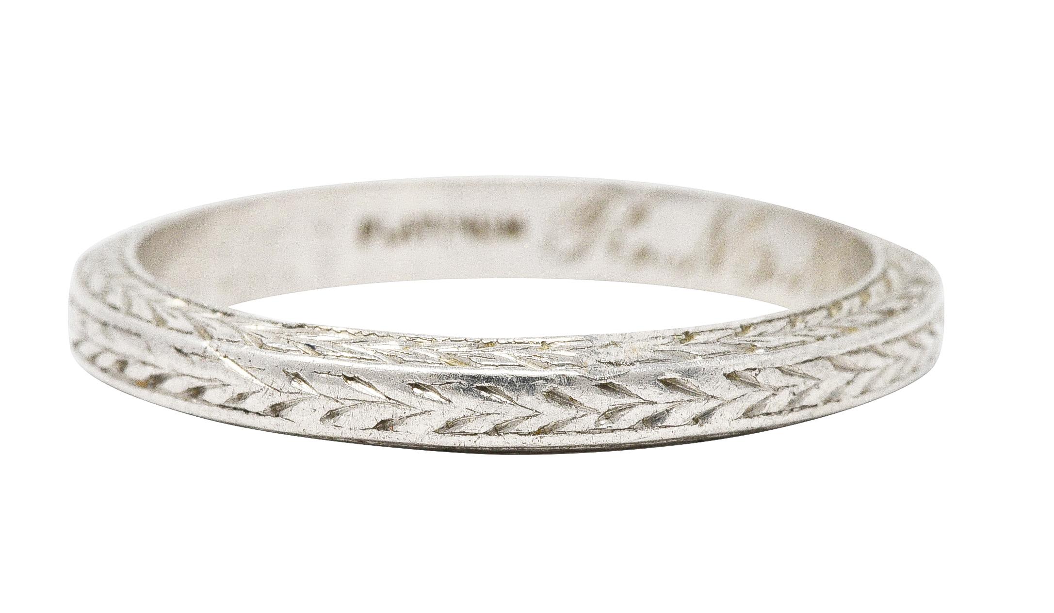 Band ring features engraved wheat motif throughout. Inscribed 'R.M.M. and D.M.W. Feb. 21. 24'. Stamped for platinum. Circa: 1924. Ring size: 5 1/4 and not sizable. Measures: North to South 2.5 mm and sits 1.5 mm high. Total weight: 3.0 grams.