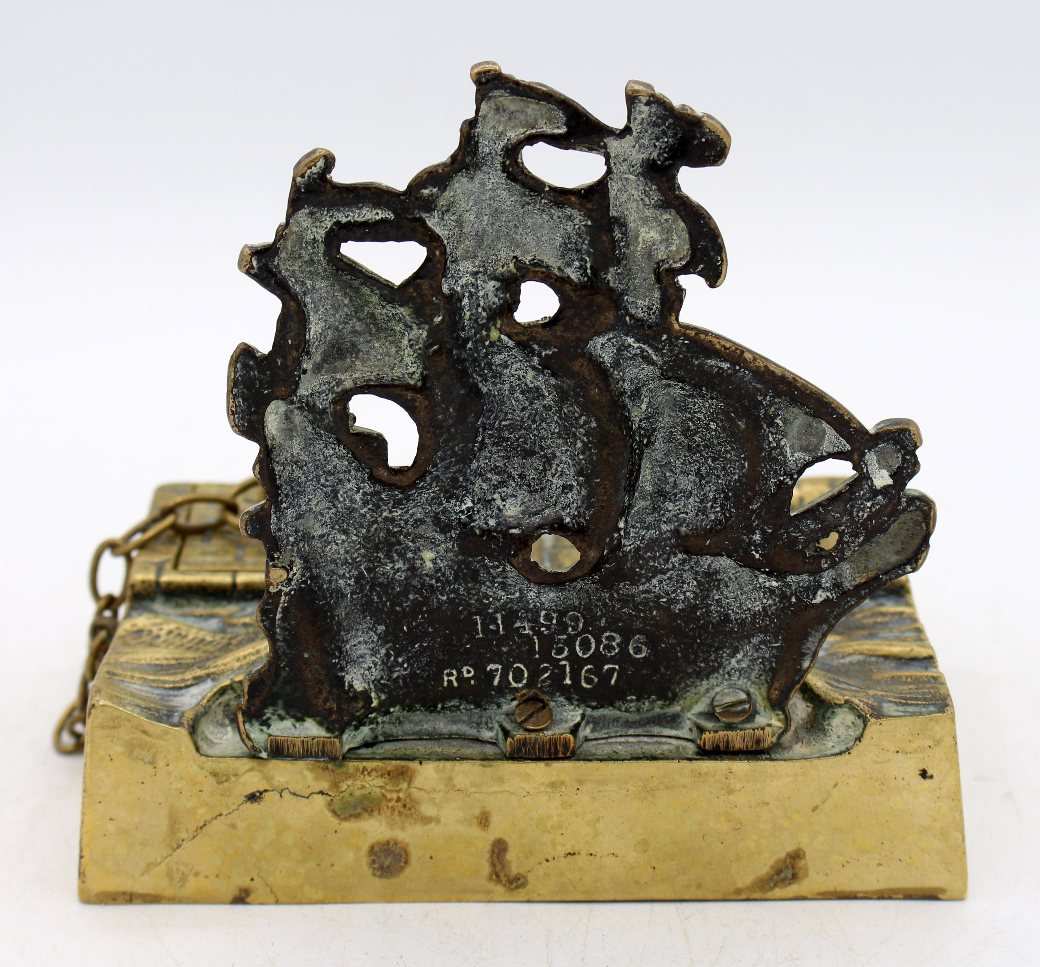 1924 brass ship inkstand, English. Featuring a Man of War in full sail just off the stone sea wall - the sea wall houses the nib tray & inkwell, the sea waves hold the pens. Marked Rd. 702167 for the year 1924.
5.5