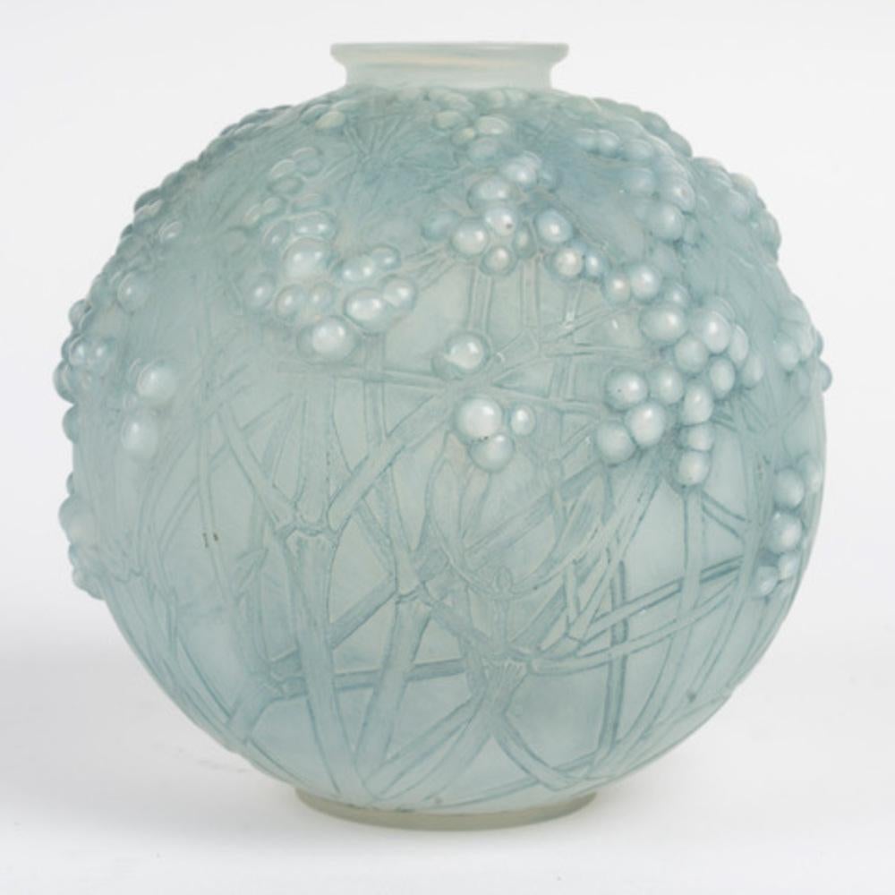 “Druid” vase in mold-blown opalescent glass  enhanced with a blue patina  

Model created by  René Lalique in 1924 and removed from the catalog in 1937  

Signature engraved on the back. 

Height: 18 cm 

Bibliography: Félix Marcilhac, René Lalique