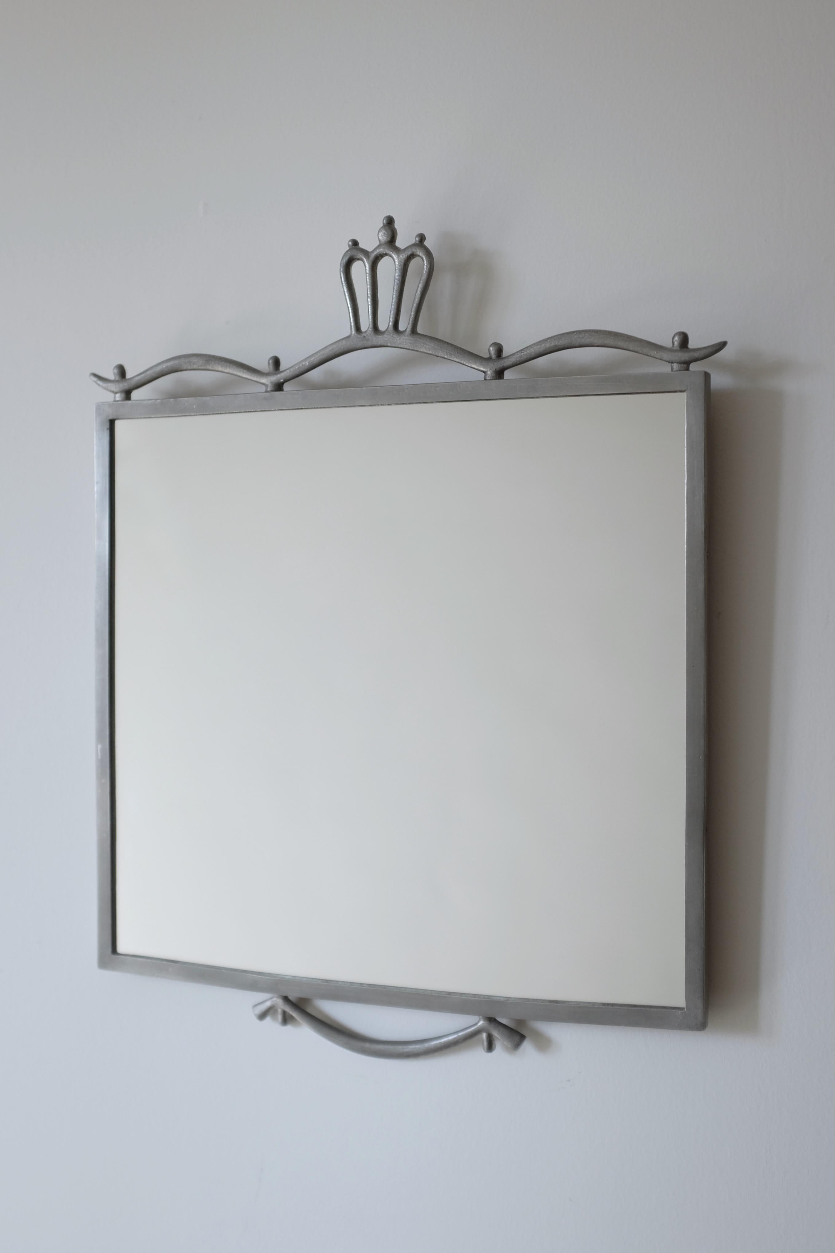 Beautiful Swedish Grace Pewter Mirror by Edvin Ollers from 1924. An almost square design with decorative ornaments at the top and bottom of the mirror. New glass and marked with designer name and year of manufacturing. Edvin Ollers was a Swedish
