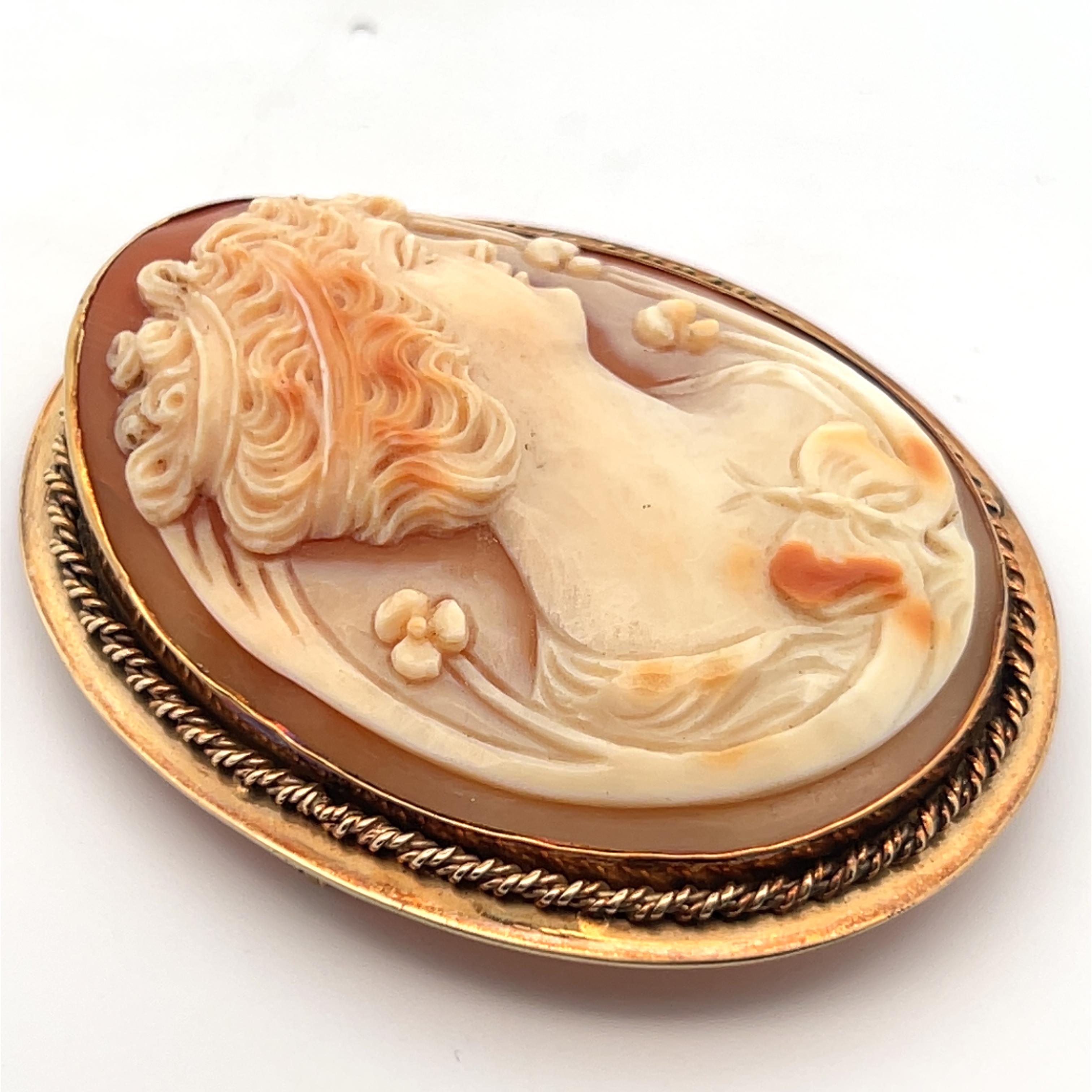 Cette épingle/pendentif provient de la période Art déco de 1925 et présente un grand camée en coquillage naturel sculpté à la main avec 3 couleurs de coquillage, réalisé en or jaune 14k. Ce pin's mesure 6,0 x 3,6 cm, ce qui signifie qu'il se fera