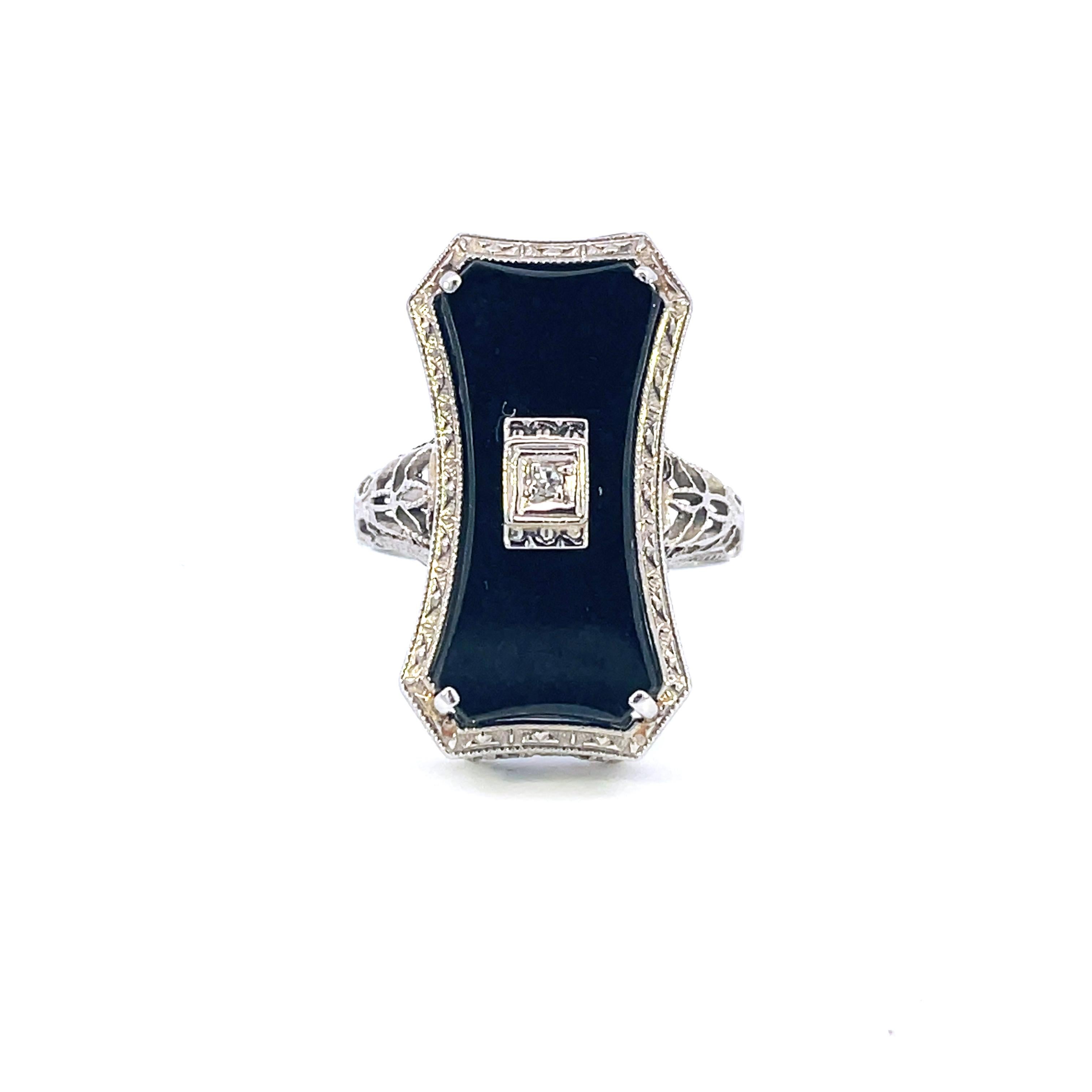 Dieser einzigartige Art-Déco-Ring aus 14-karätigem Weißgold zeigt eine wunderschöne Tafel aus schwarzer Jade, die in der Mitte mit einem weißen Diamanten verziert ist. Der wunderbare Deco-Ring ist mit herrlichem und fantasievollem Filigran entlang