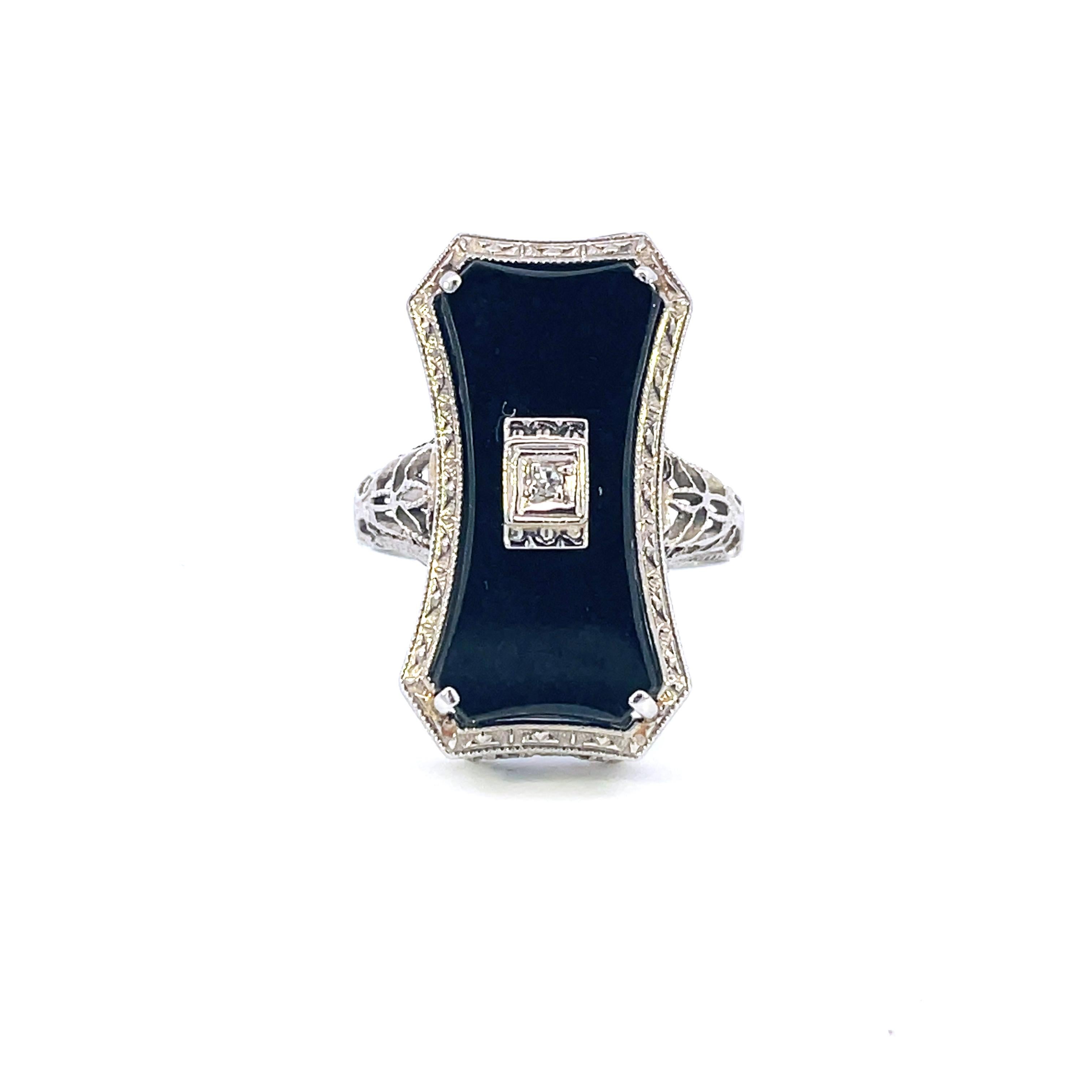 Il s'agit d'une bague Art déco unique, réalisée en or blanc 14 carats, qui met en valeur une magnifique tablette de jade noir ornée d'un diamant blanc en son centre. Délicieusement déco, la bague présente un filigrane merveilleux et fantaisiste le