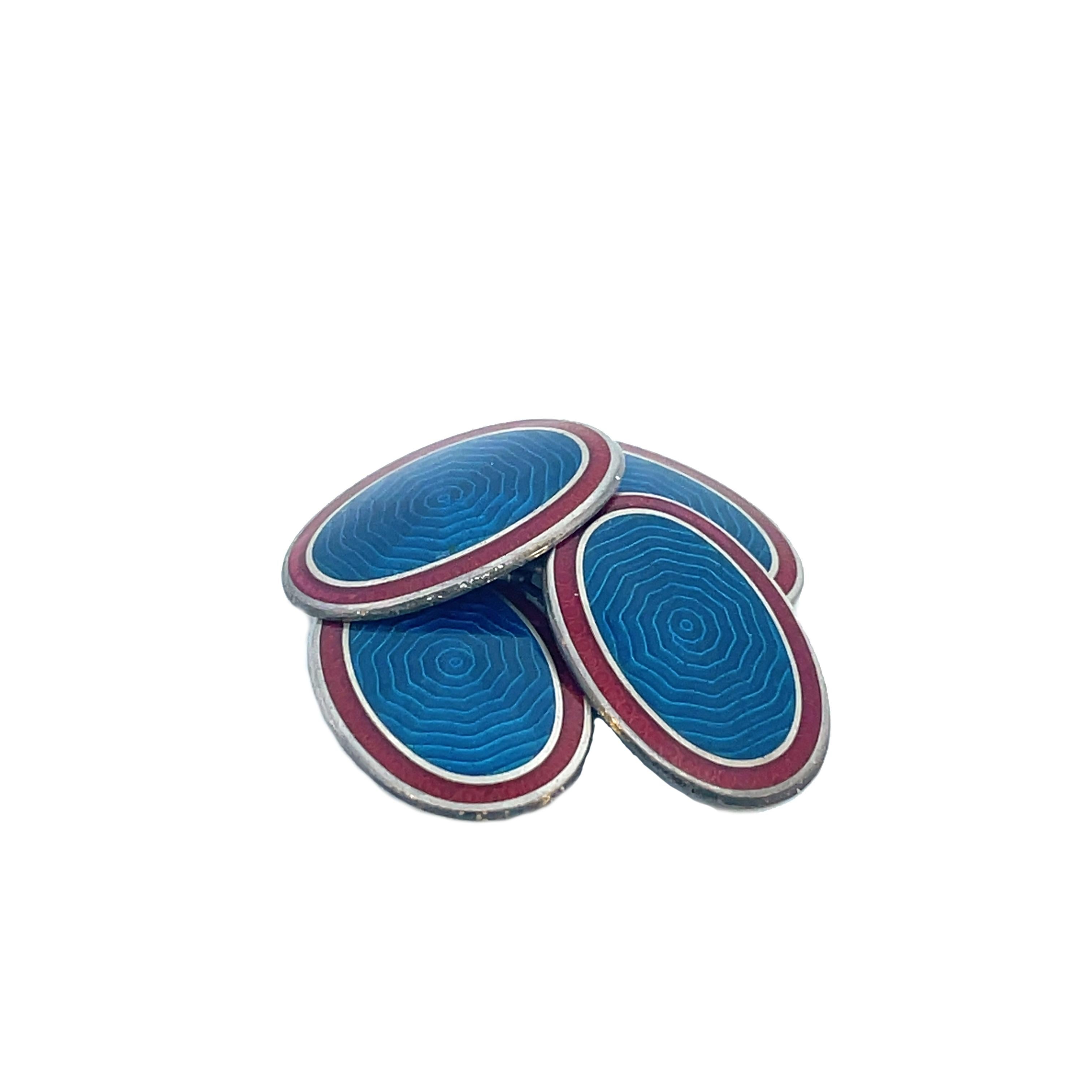 This is a smashing pair of Art Deco cufflinks crafted in sterling silver and vibrant red and blue enamel! These links are the perfect addition to any gentleman's wardrobe. Stunning steel grade blue at the center, with fanciful swirling lines, and a