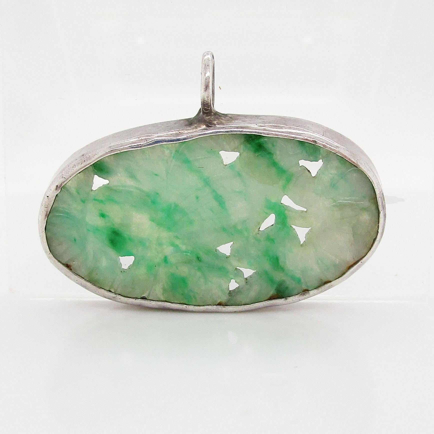 This is an absolutely beautiful piece of carved jade bezel set into an Art Deco sterling silver pendant. The jade is Chinese export and a truly exquisite green color! The jade is hand carved and pierced with a lovely floral bird motif. This piece of