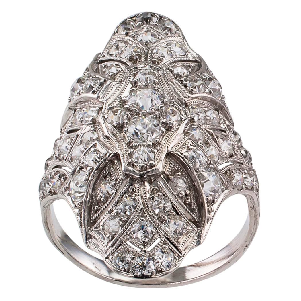 Art Deco 1925 diamond and platinum dinner ring. The slightly domed design lavishly decorated by millegrained filigree work, on a platinum mounting frosted by fifty-four old round cut diamonds totaling approximately 2.50 carats, approximately G - H
