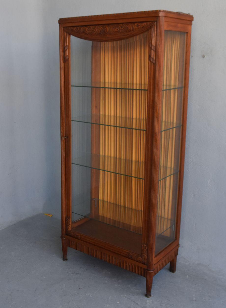1925 Art Deco oak display case tapered legs work in the spirit of Paul Follot, rich sculptures of drapes and garlands of flowers. Ideal showcase for presenting a collection of Art Deco objects or glass paste. Height dimension 171 cm for a width of