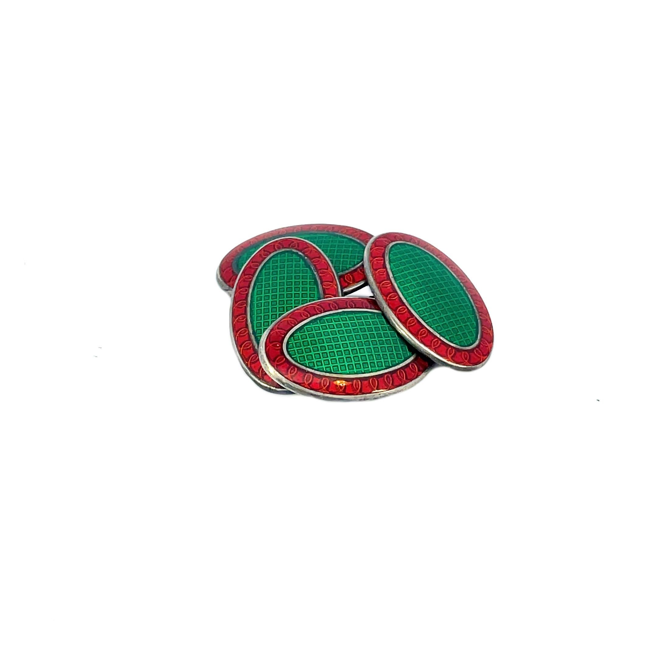 This is a handsome pair of 1925 Art Deco cufflinks crafted in sterling silver with a stunning vibrant red and green guilloche enamel face. Dashing and vibrant, these cufflinks are sure to catch anyone's eye! A vibrant cherry red border adorned with