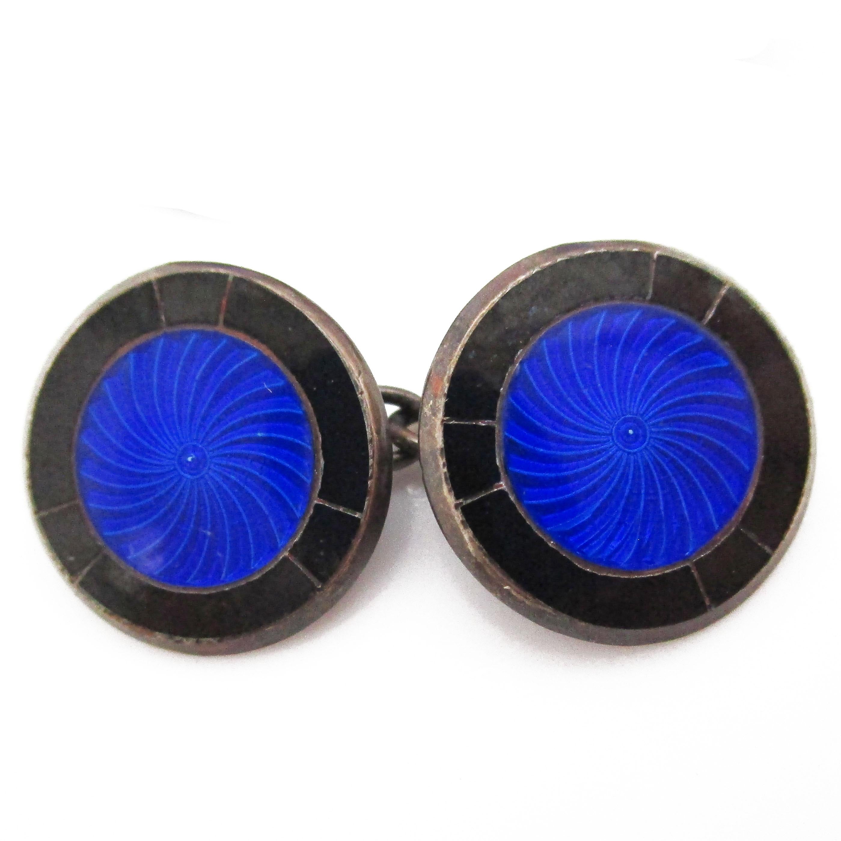 These excellent Art Deco cufflinks are from 1925 and feature a classic pairing of bright sterling silver and rich royal blue enamel. The sleek round design of the cufflinks makes them easy to wear, and the great color scheme means they will look