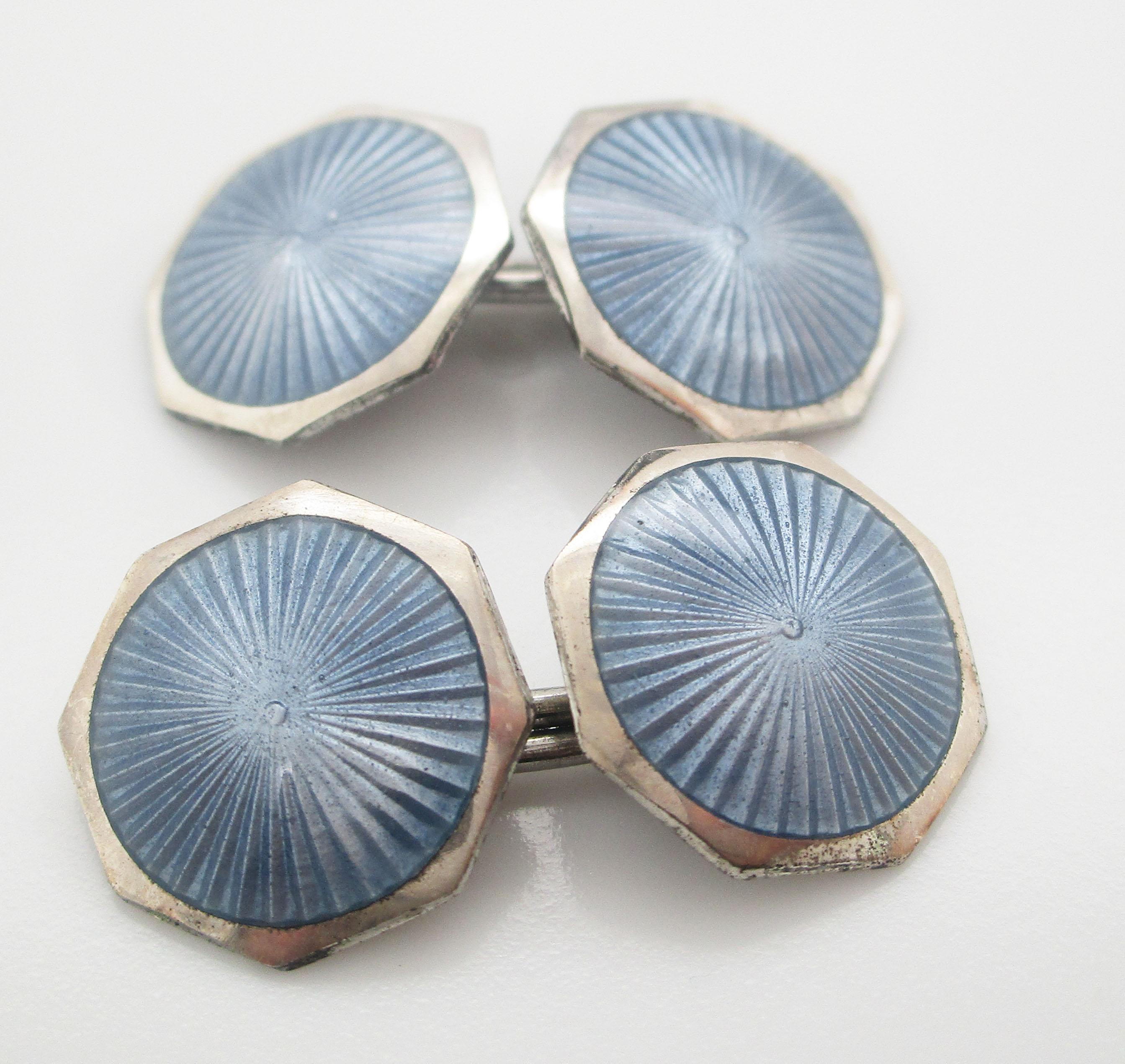 These cufflinks deliver the classic elegance of the Art Deco era in an elegant combination of sterling silver and steel blue enamel. The links have a sleek octagonal shape with a sterling silver border and a subtly detailed radial guilloche enamel