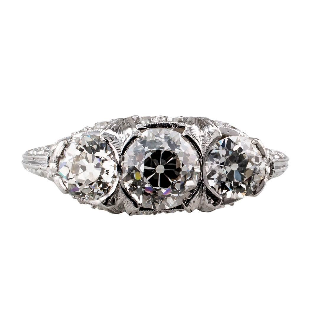 Art Deco 1925 Old European cut three stone diamond platinum ring. Centering upon an old European-cut diamond weighing approximately 0.97 carat, approximately G – H color and VS clarity, between two similarly cut diamonds together weighing
