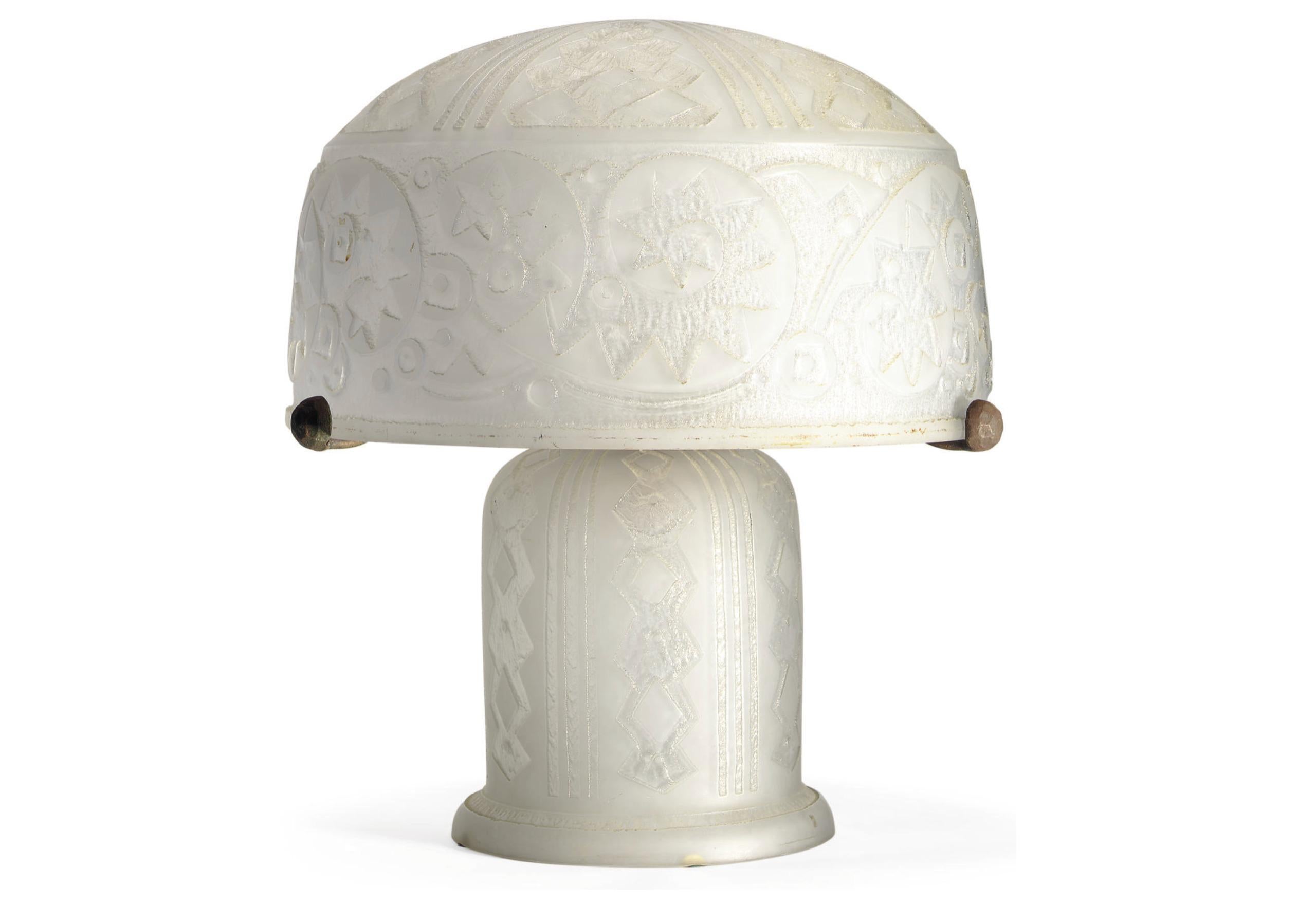 DAUM Nancy France Table lamp, circa 1920/25

Clear glass with acid-etched stylized geometric motifs.
The semi-spherical lampshade is held in place by a wrought iron metal structure  with three arms, each ending in a small hammered and patinated