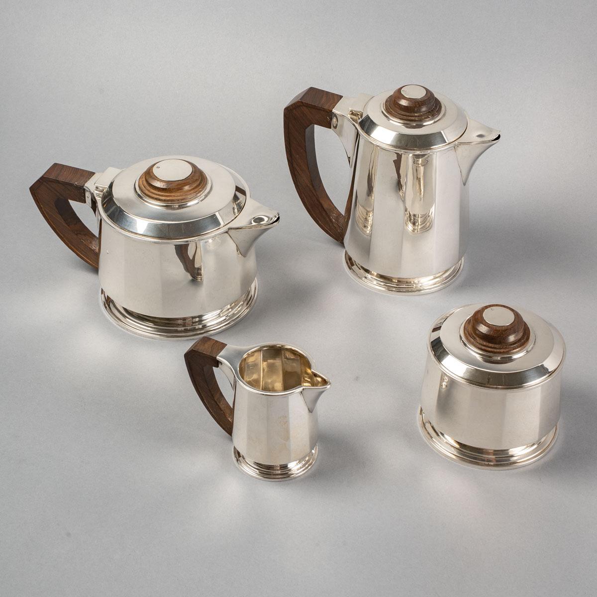 Tea and coffee service with cut sides in sterling pure silver and rosewood by Jean E. Puiforcat.

Service including :
- a coffee pot 18.5 cm x 18.5 cm
- a teapot 13.5 cm x 22 cm
- a milk jug 8 cm x 11 cm
- a sugar bowl 10.5 cm x