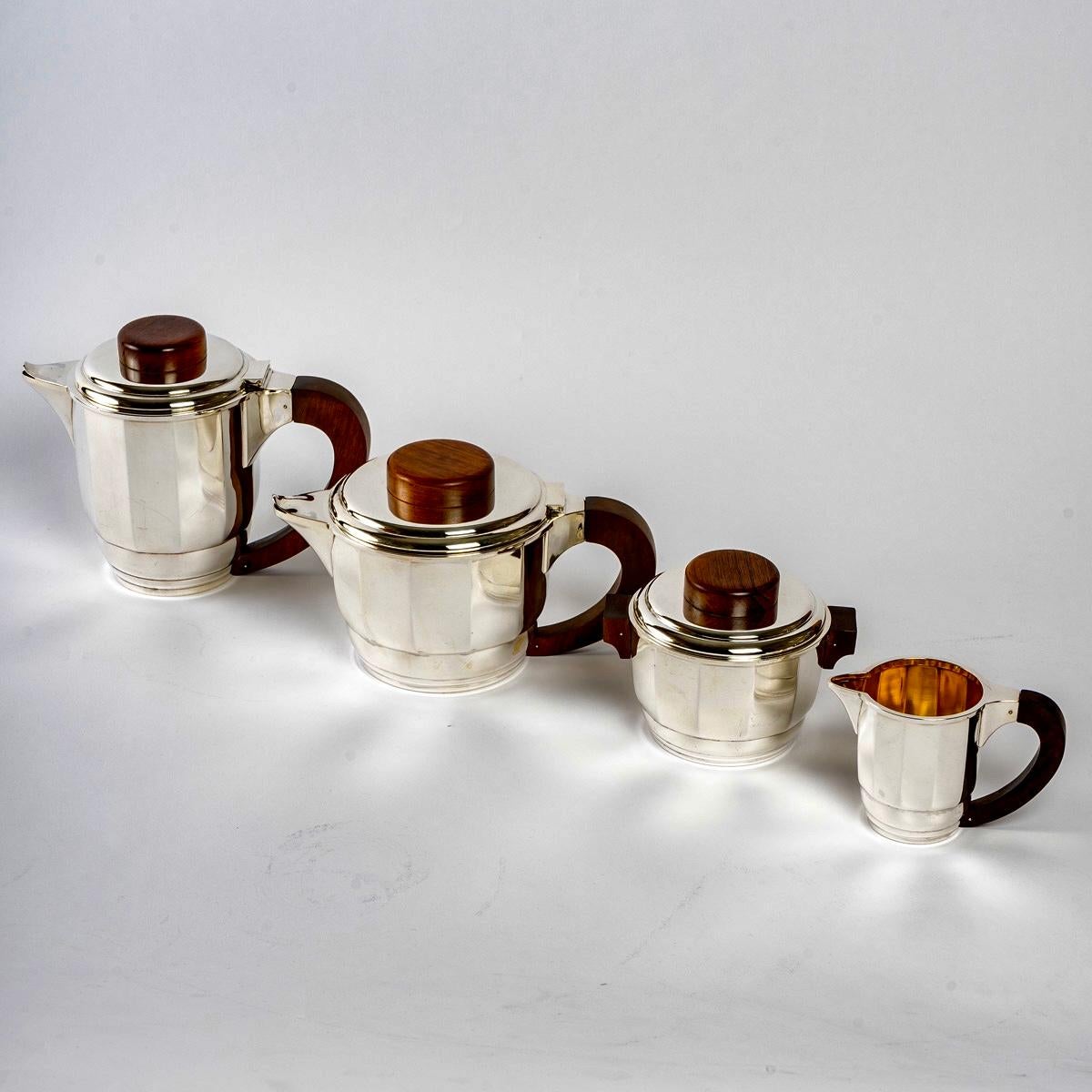 Art Deco tea and coffee set in sterling pure silver and rosewood by Puiforcat created in the 1925s.

Service including:
- a coffee pot 
- a teapot 
- a milkpot
- a sugar pot 

Minerve Solid Silver 950/1000 French mark - maker's stamp on each