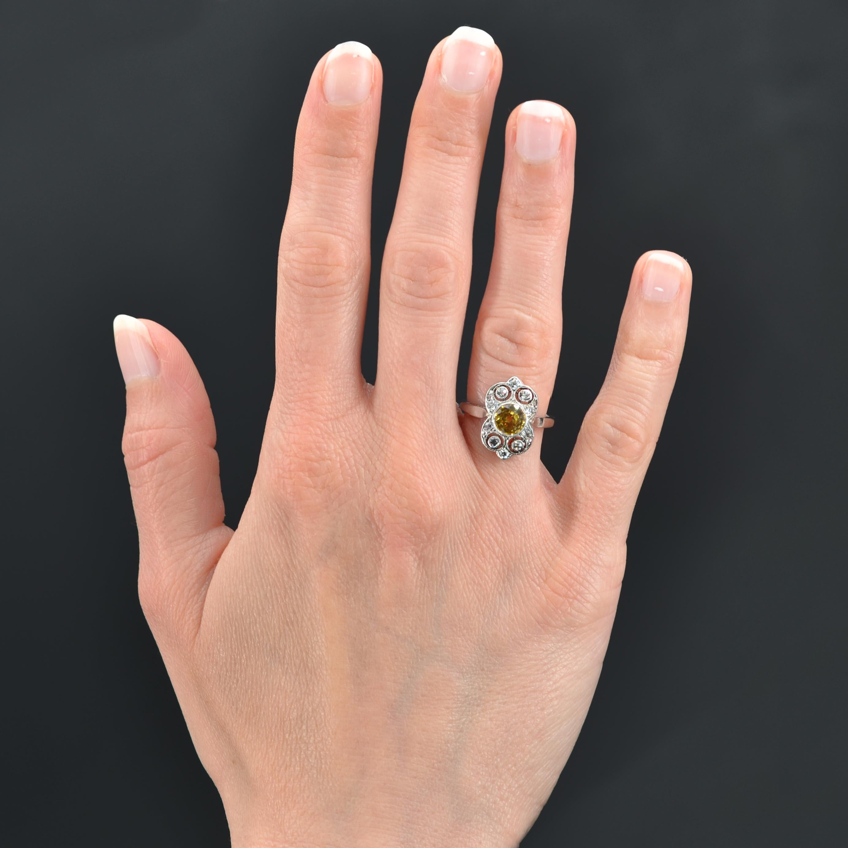 Ring aus Platin.
Charmanter Art-Déco-Ring, in der Mitte ein leuchtend gelber Saphir in einer durchbrochenen Verzierung, besetzt mit einem Diamanten im Antikschliff und Diamanten im Rosenschliff in verschiedenen Größen.
Gewicht des Saphirs: ca. 1,17
