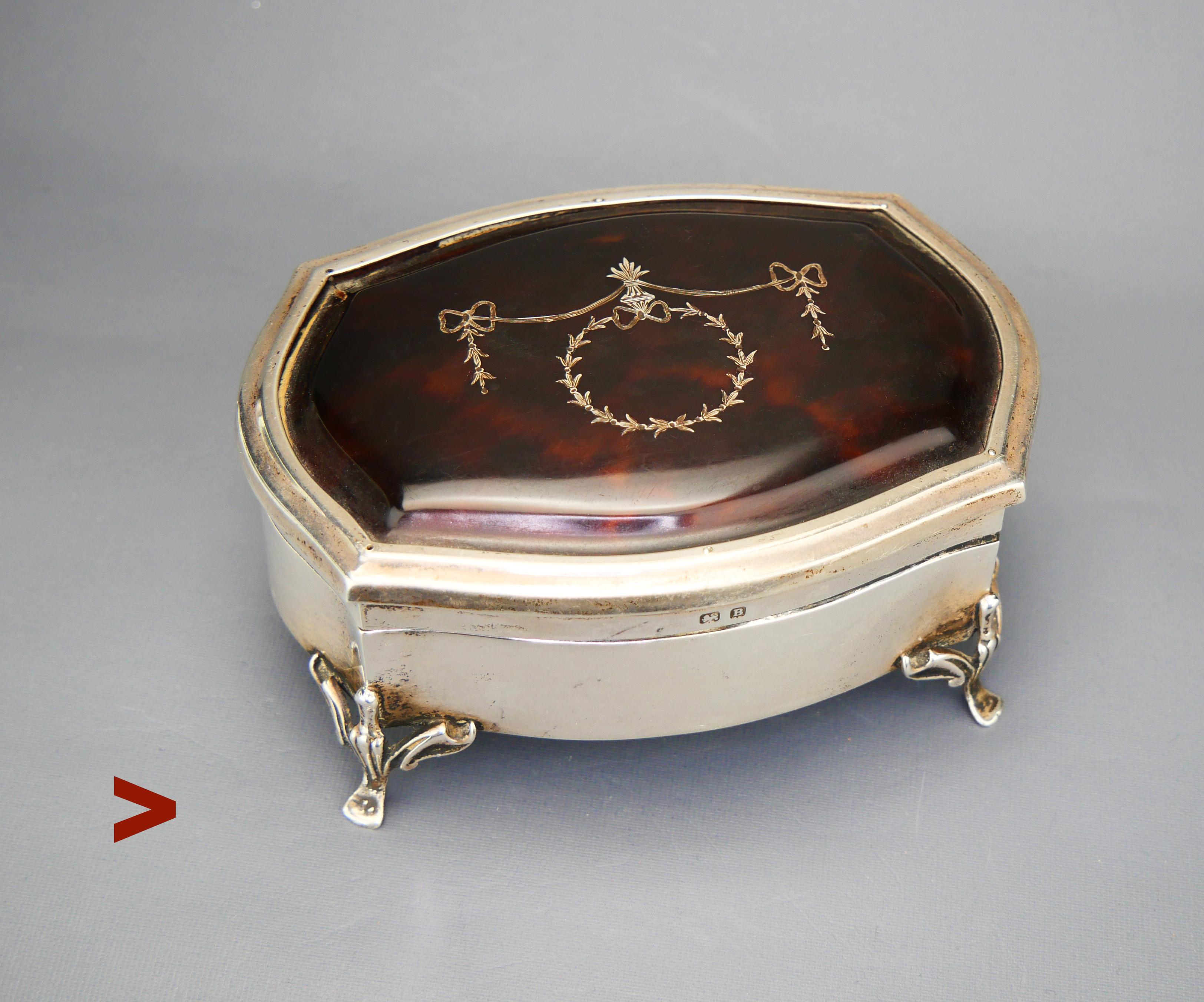 British Jewelry Box on cabriole legs, interior lined with beige colored textile.Lid with a mounted bone plate decorated with ornamental inlay in Silver.

Made in England. The item is hallmarked with logo of  Asprey & Co. Ltd. Birmingham with