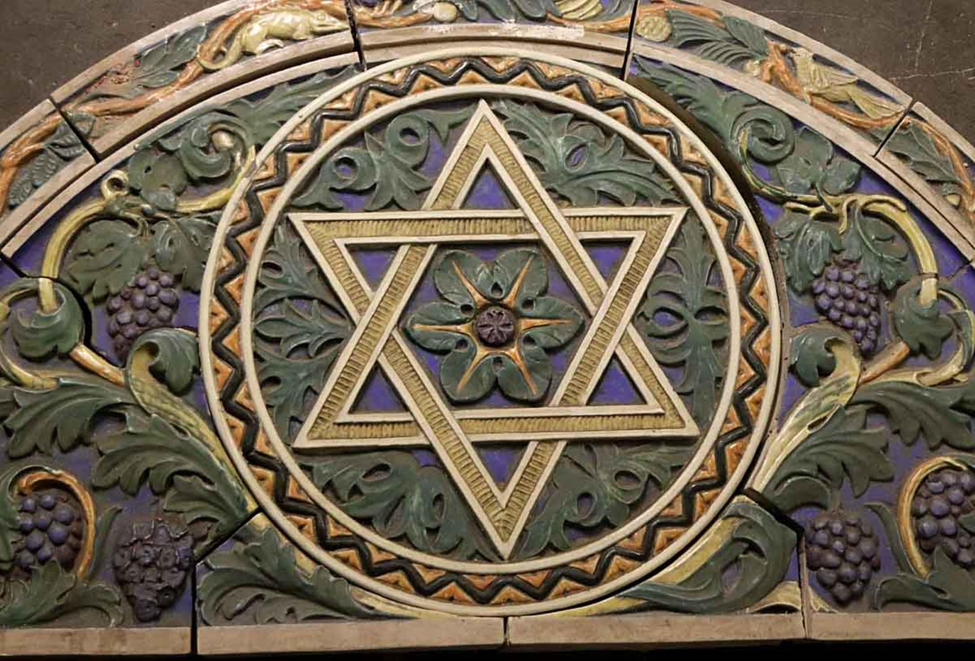 Der polychrome Terrakottabogen von 1926 gehört zu einer Gruppe von Bögen, die wir aus einer Synagoge in Philadelphia aus dem Jahr 1926 übernommen haben. Auf diesem ist der Davidstern abgebildet, auf anderen eine Menora und die Thora sowie