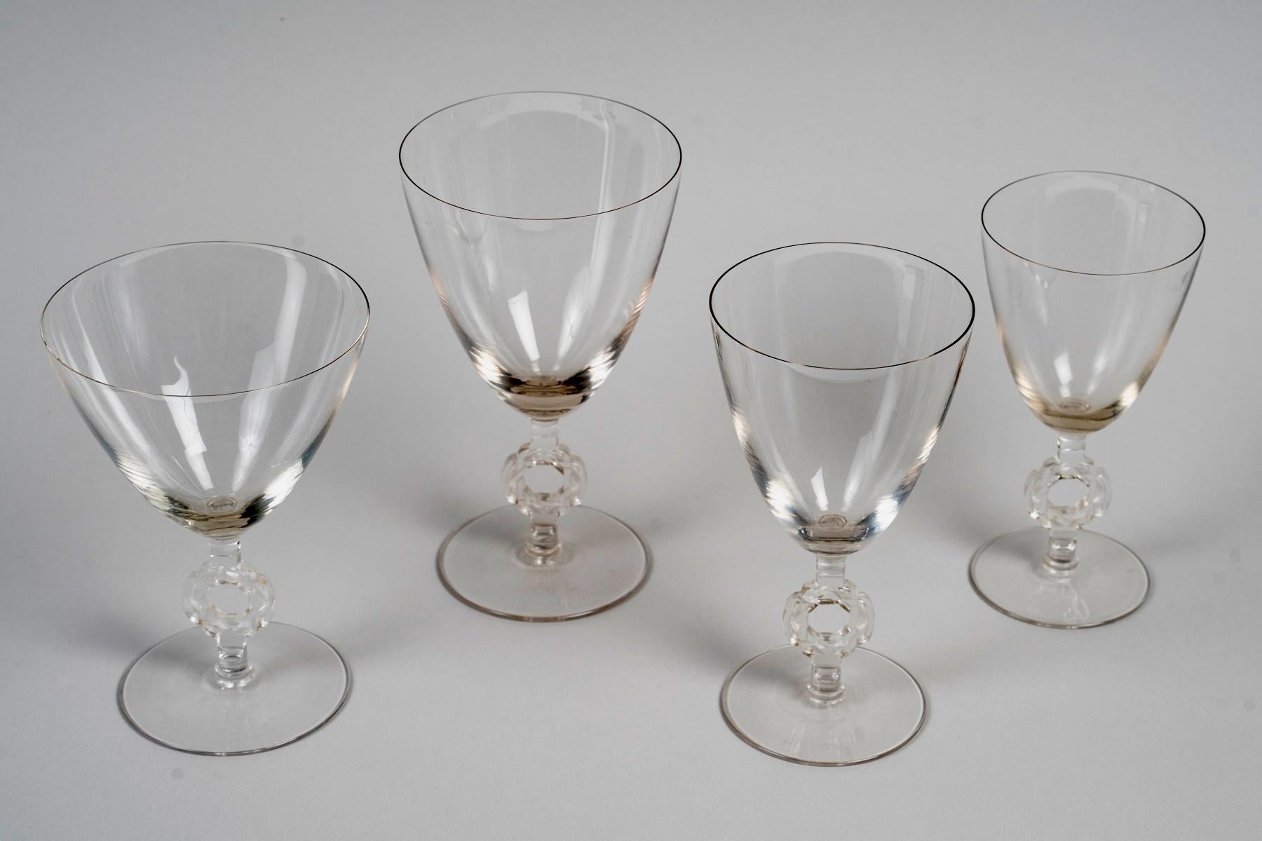 Set “Ribeauvillé” decorated with a Star of David made in clear glass by René Lalique in 1926.
“R.Lalique” signature under each glass.

Set for 15 people including:
- 15 champagne glasses - 14.2 cm high
- 15 water glasses - 16.2 cm high
- 15 red wine