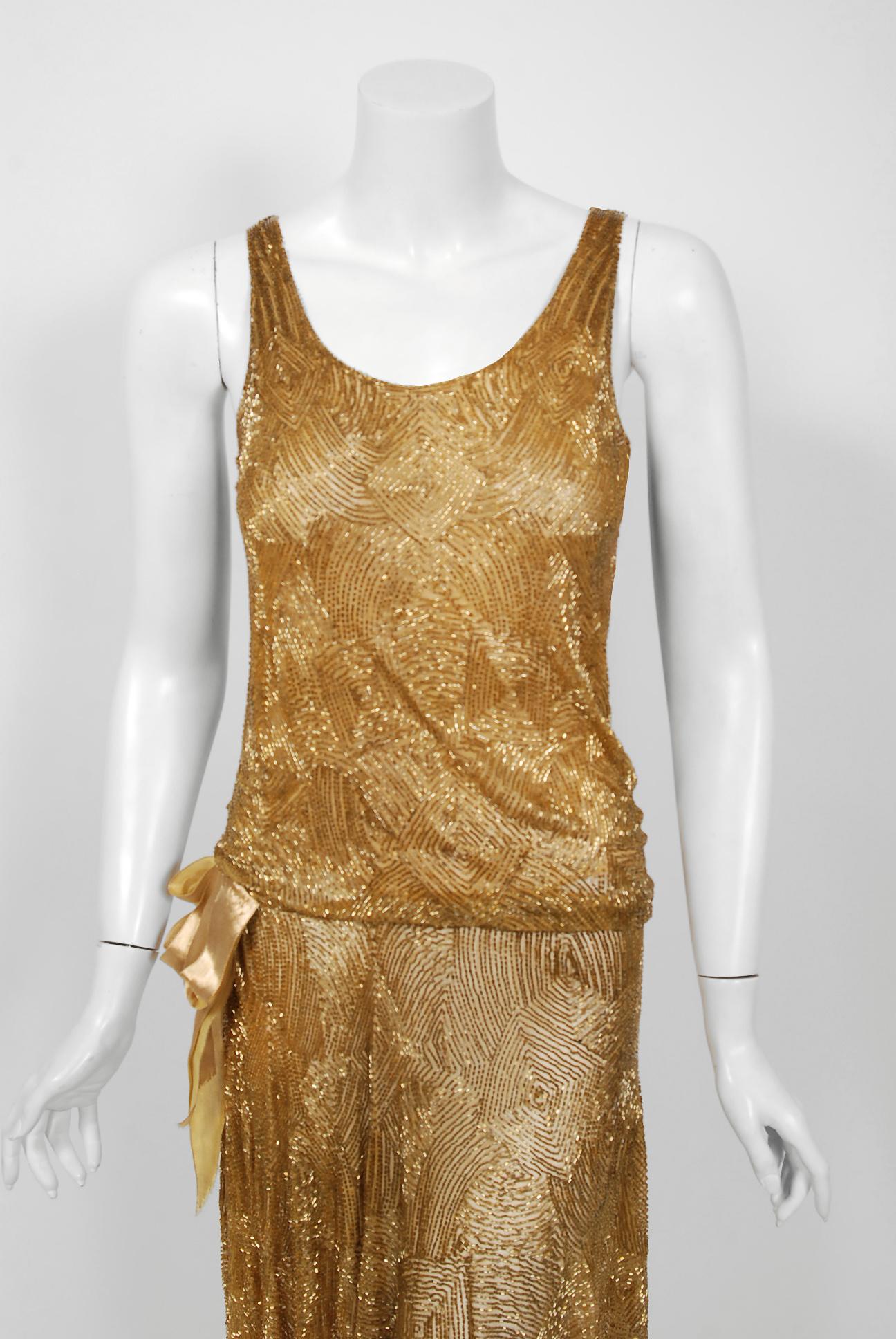 Yvonne of Paris was one of the smaller elite couture houses operating during the art-deco era. This breathtaking garment, all hand-stitched, is fashioned with golden bugle beads on matching gold cotton-net and an inner cotton netting to help keep
