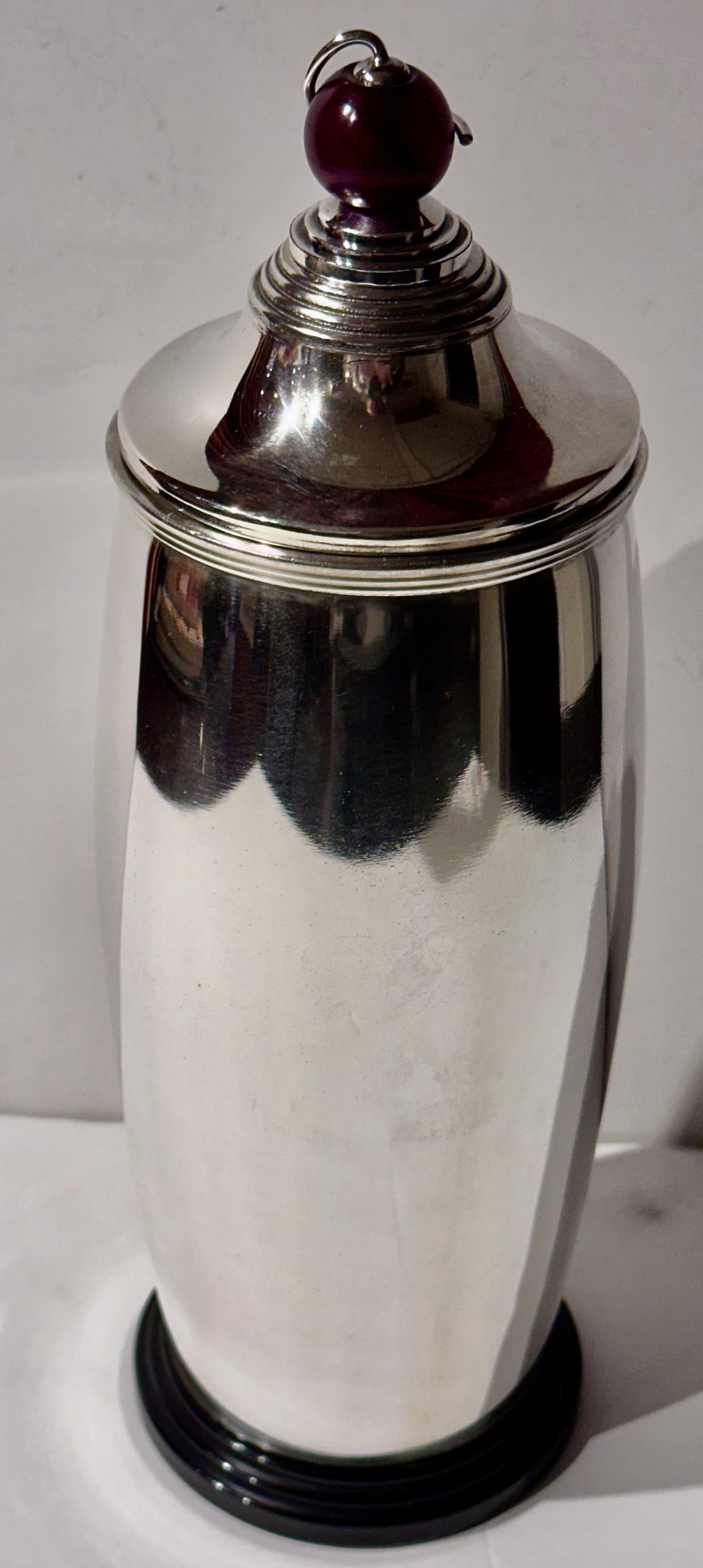 This 1927 Meriden International Silver Cocktail Shaker with an Amber Ball Top is a stunning example of functional art from the Art Deco period. The shaker’s standout feature is its unusual top, which adds an intriguing element to its