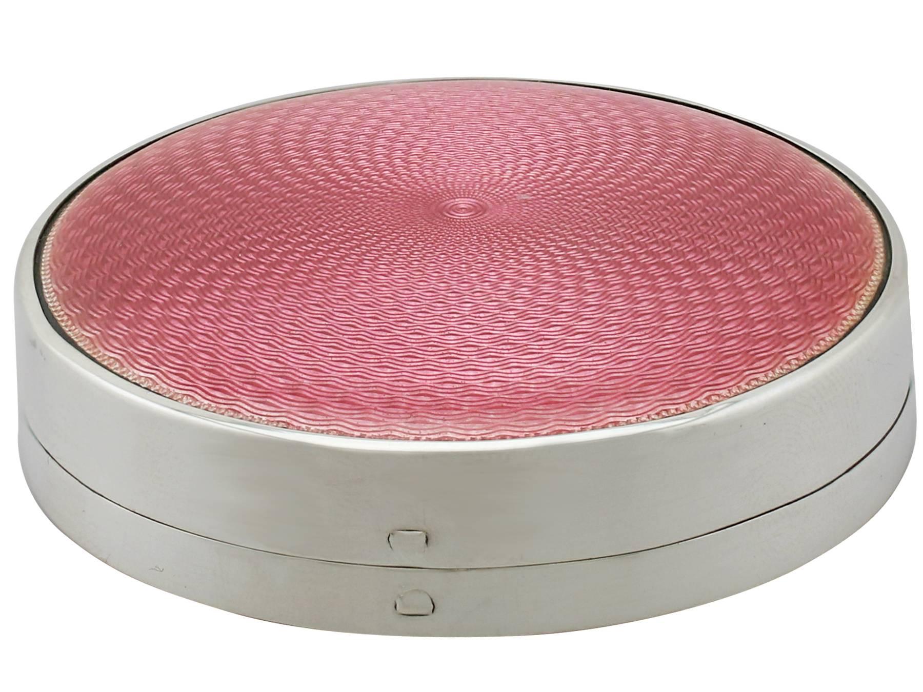 An exceptional, fine and impressive antique George V English sterling silver and enamel compact; an addition to our ornamental silverware collection.

This exceptional antique George V sterling silver and pink enamel compact has a cylindrical